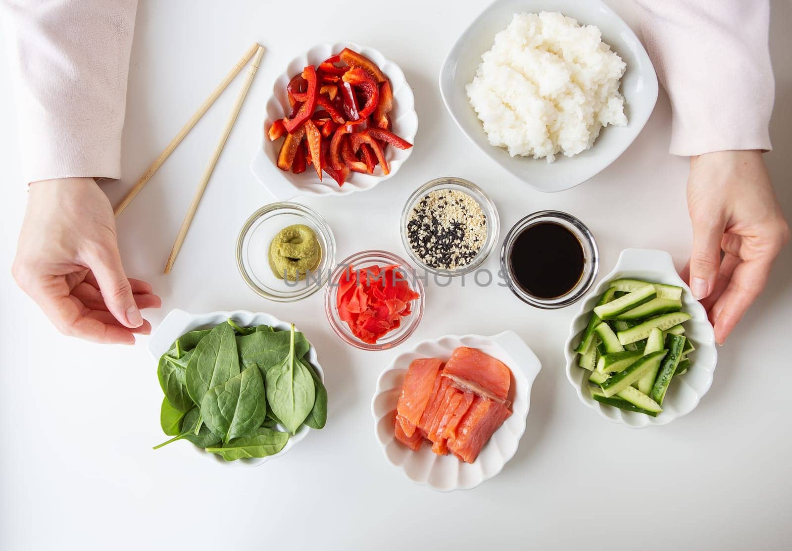 The process of preparing sushi, preparing all the ingredients for sushi, the girl is holding chopsticks for eating