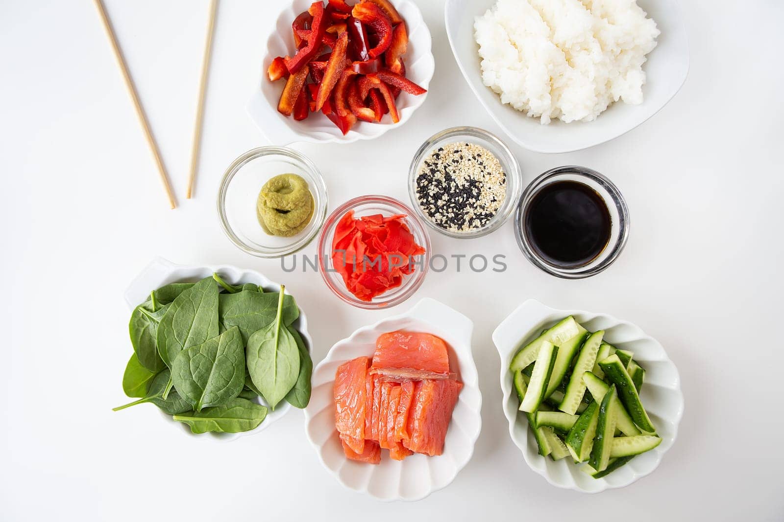 Sushi preparation process, preparation of all ingredients for sushi rice, salmon, pepper, sesame seeds, sauce, wasabi, ginger. View from above