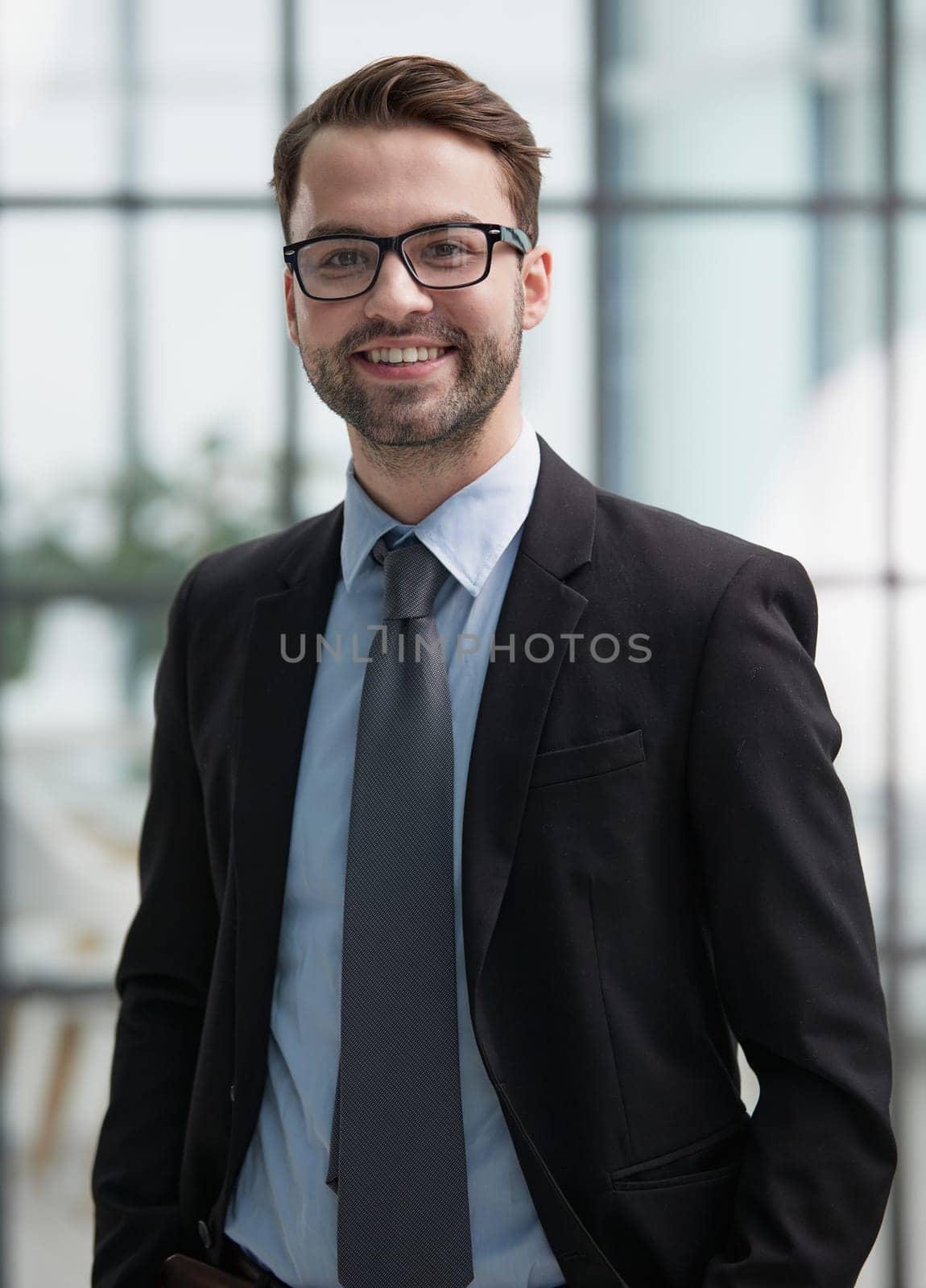 Portrait of a happy man wearing glasses and looking at the camera indoors.