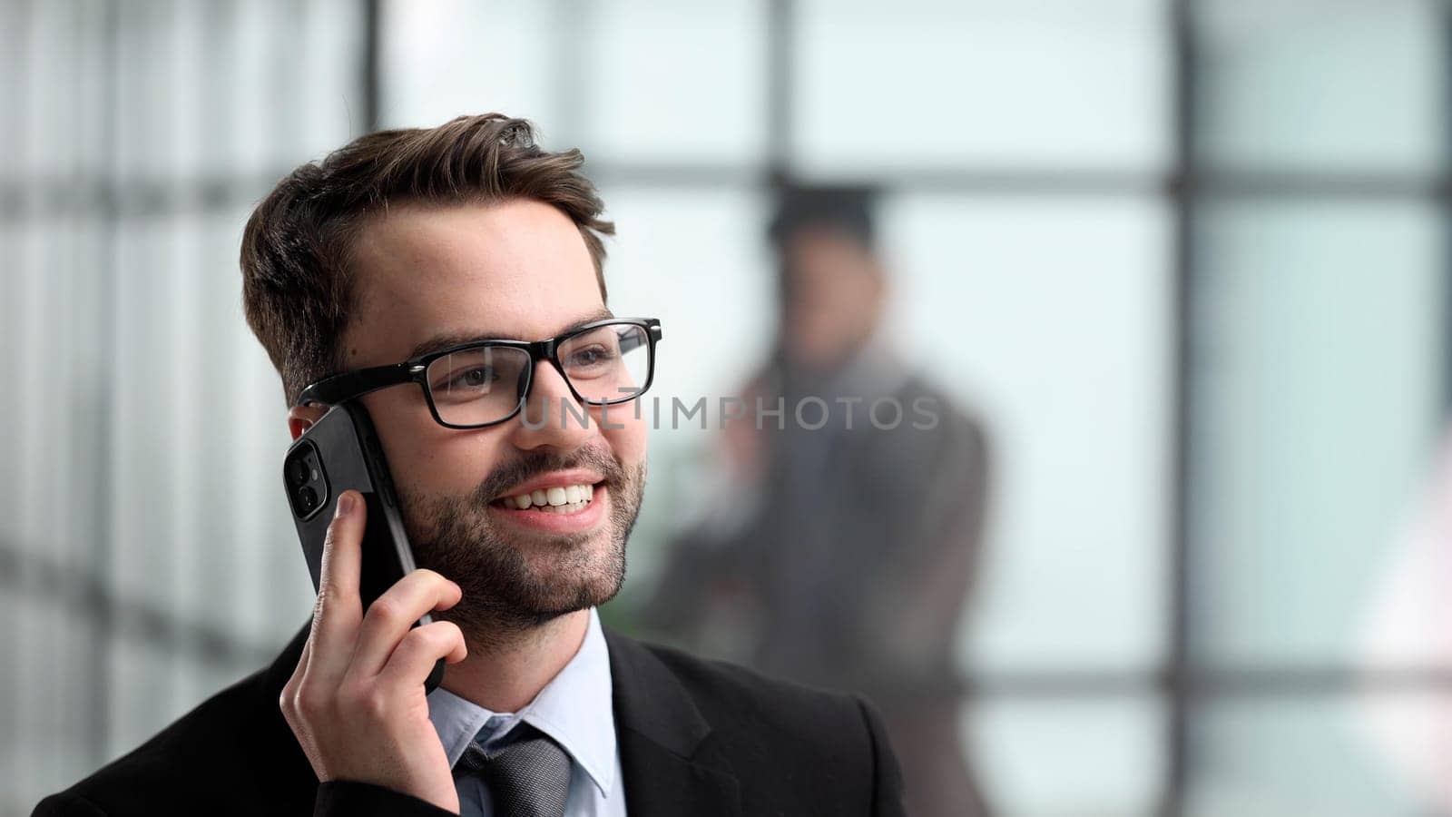 Close-up of a man in an office building talking on the phone,