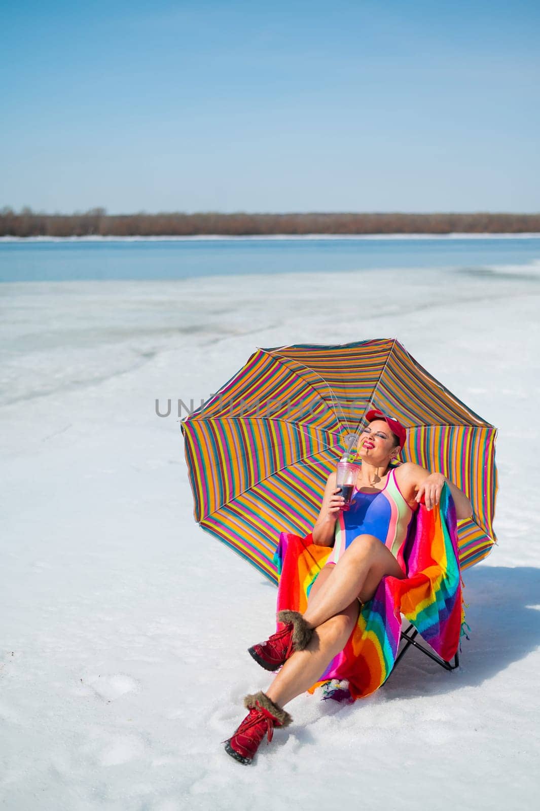 Caucasian woman in a swimsuit sunbathes on the snow in winter. by mrwed54