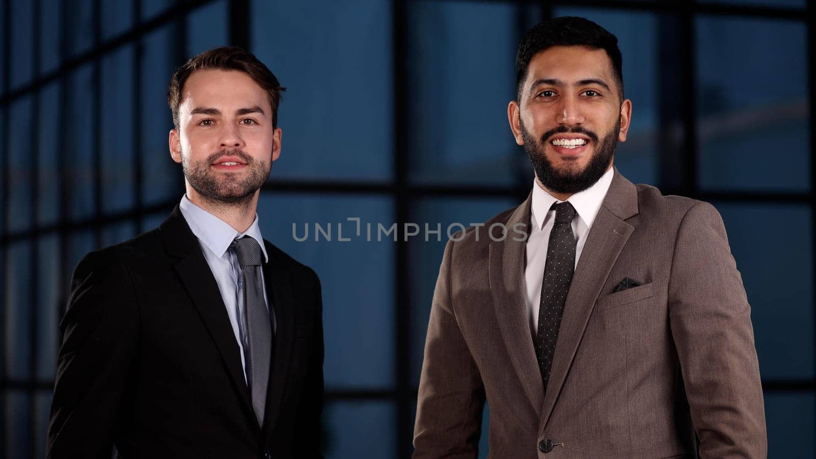 Two happy men standing with arms folded