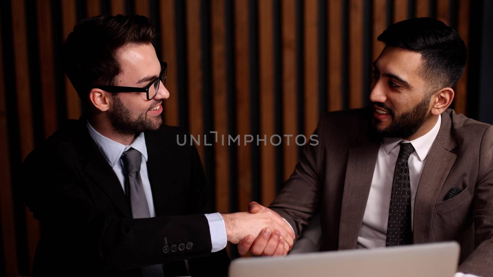 two men at the table shake hands by Prosto
