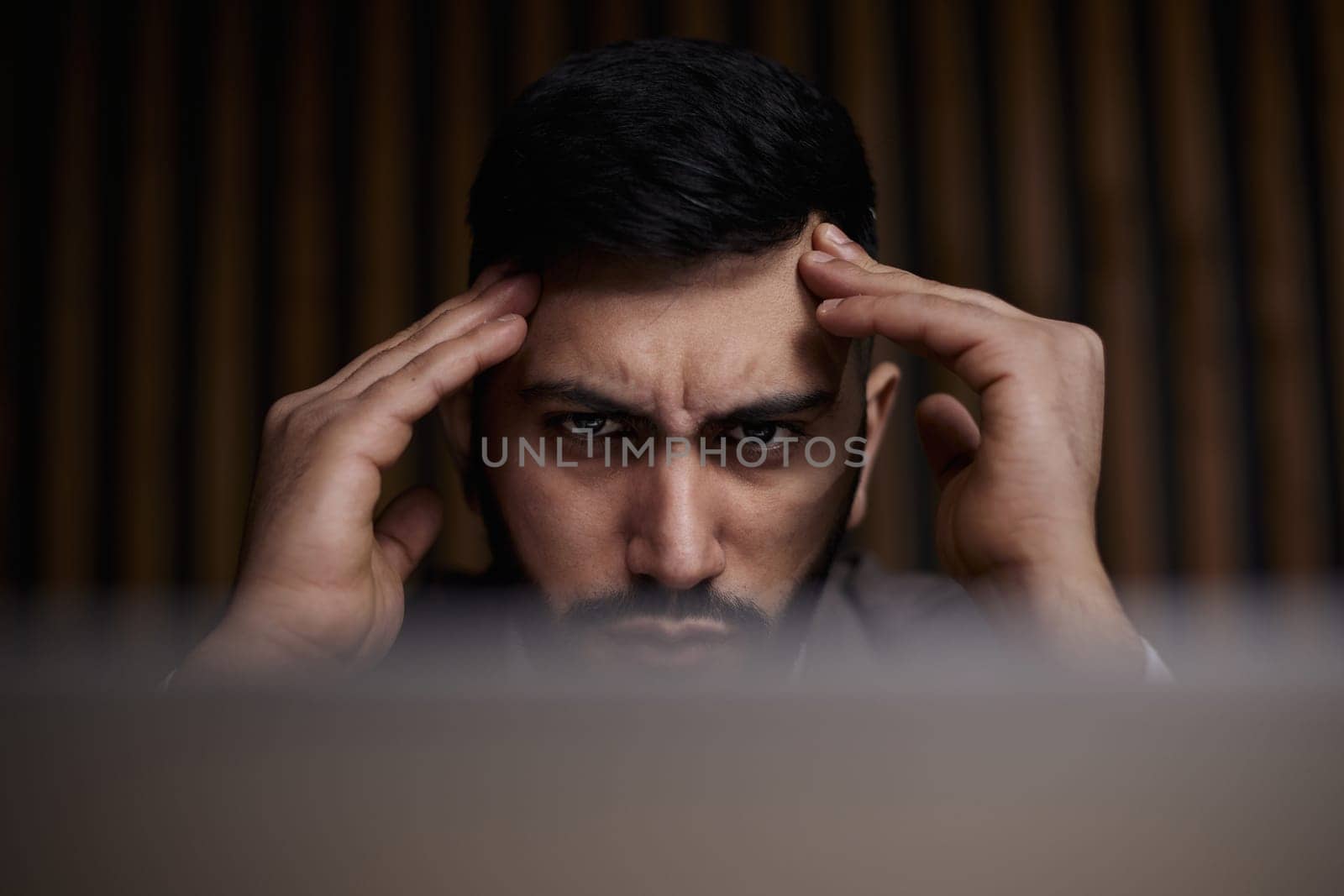 Businessman using a laptop while working late in his office
