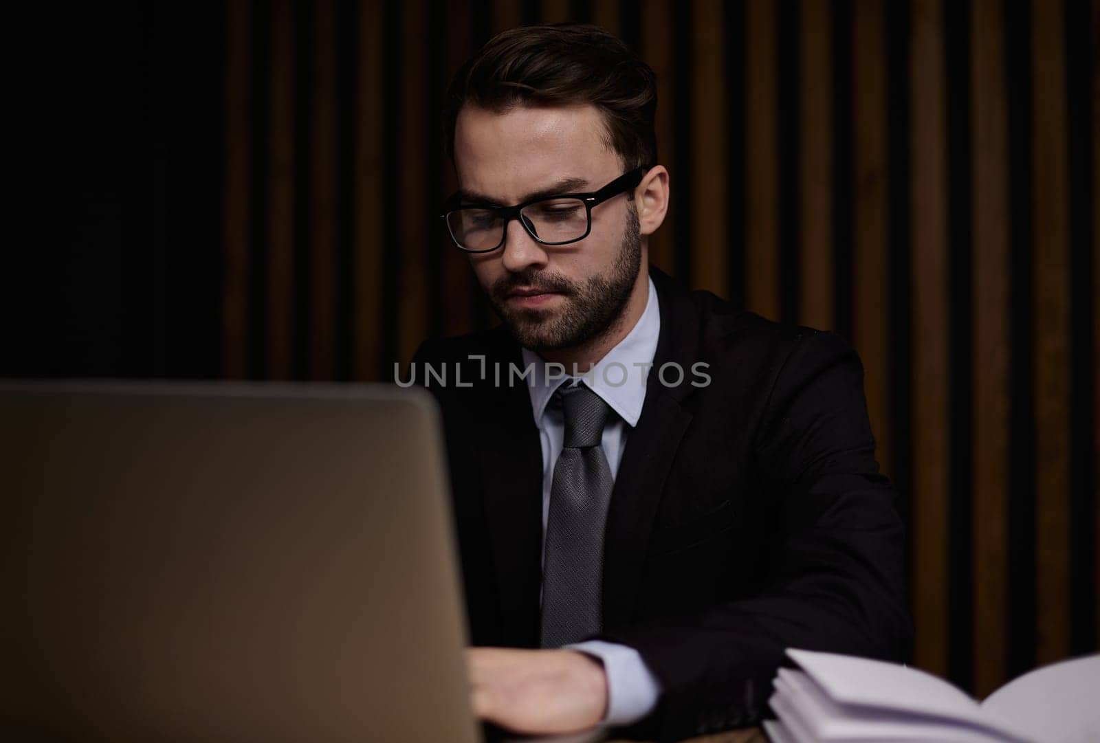 businessman working on laptop in modern office lobby space.