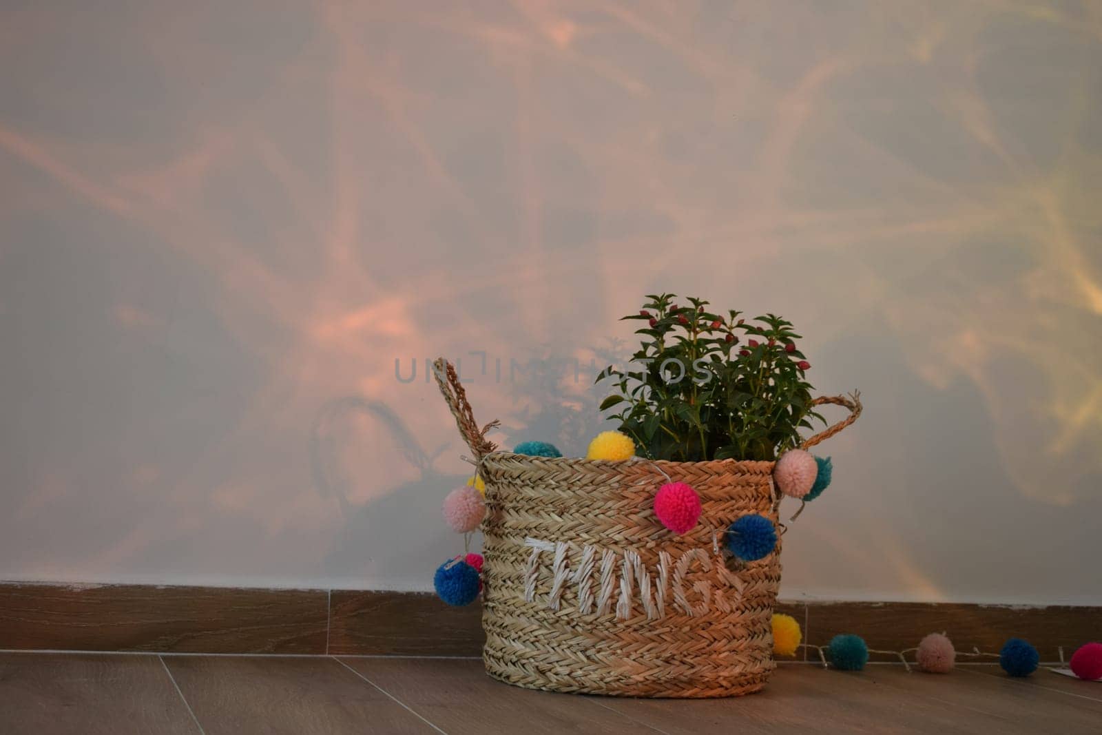 A vase of flowers decorated with decor and multi-colored balls. Bag straw.