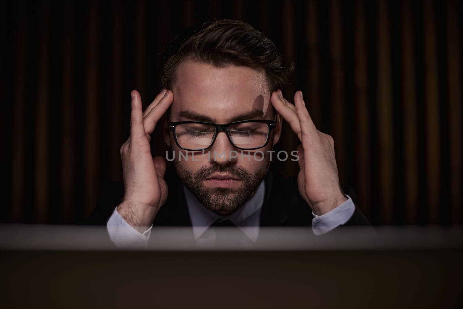 Worried businessman holding his head in his hands