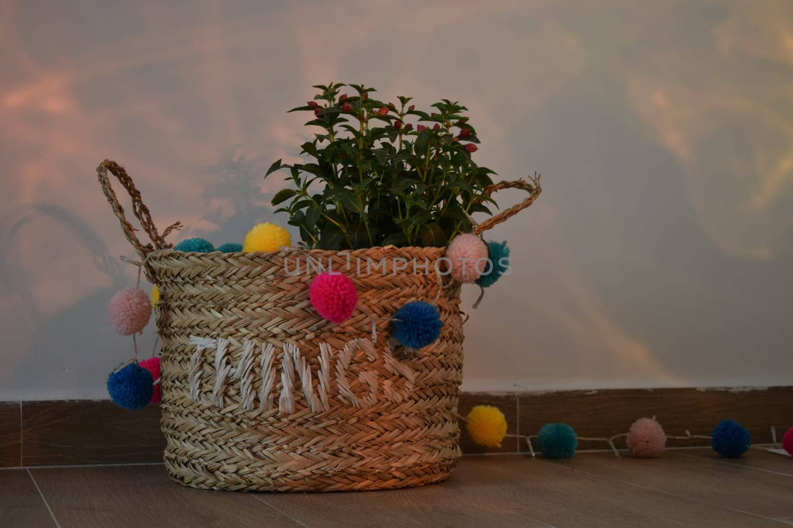 A vase of flowers decorated with decor and multi-colored balls. Bag straw.