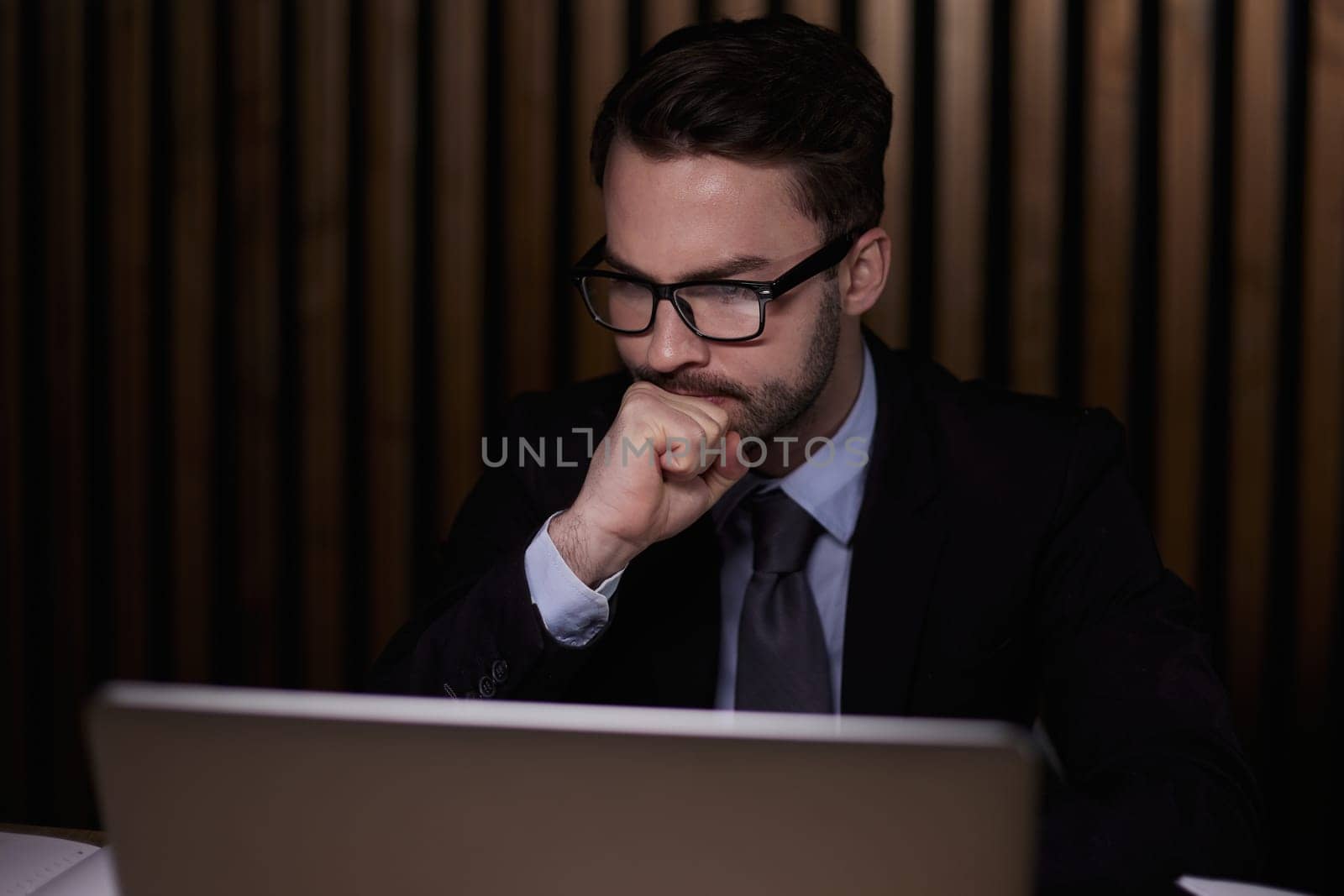The man is thinking behind the laptop.