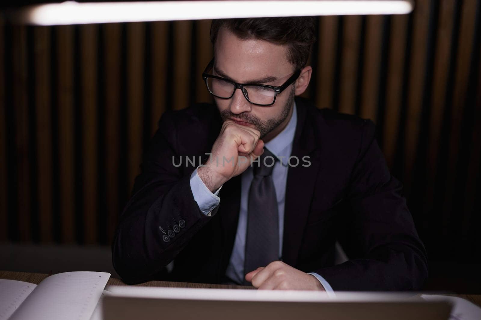 The man is thinking behind the laptop.