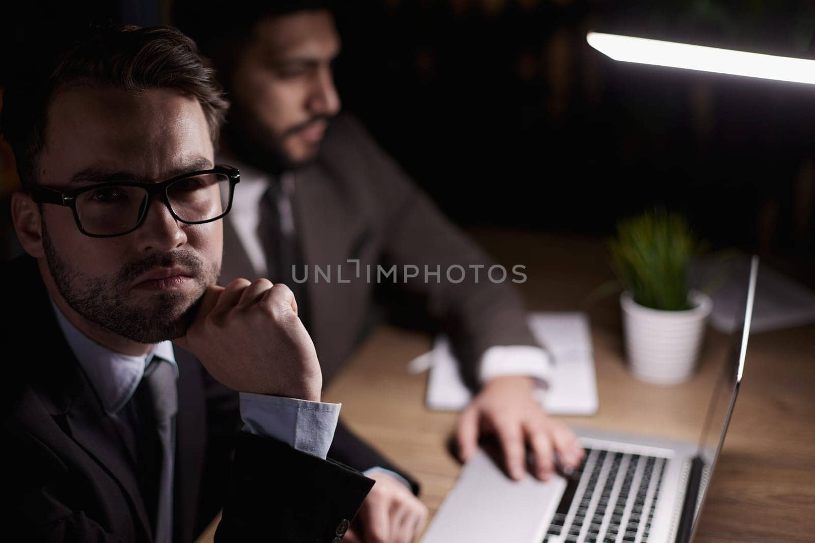 Two middle-aged business workers work at a desk in an office.