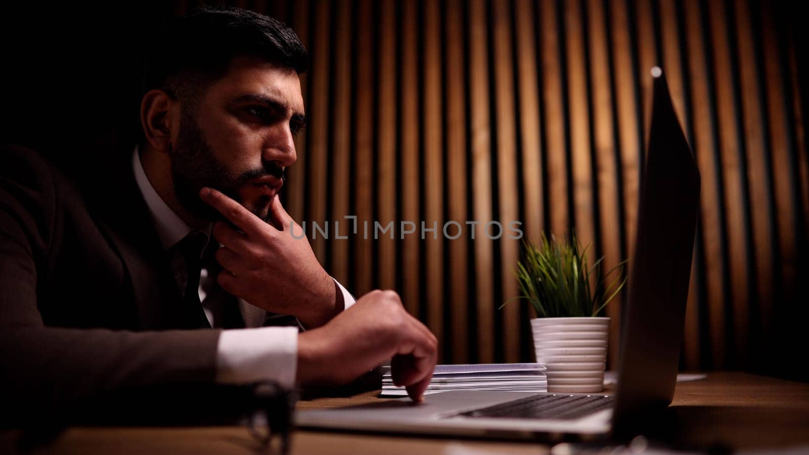 A young guy, a programmer or an entrepreneur i behind a laptop.