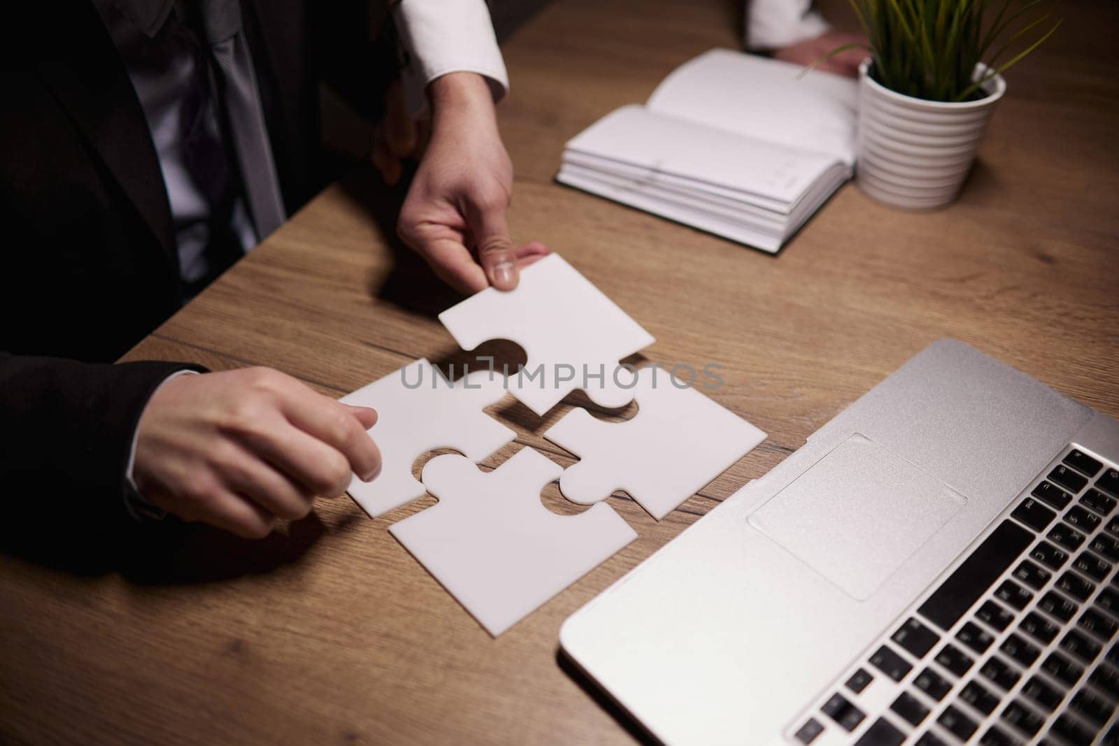 Crop close up of businessman hold pieces of jigsaw puzzle think of business problem solution or idea.