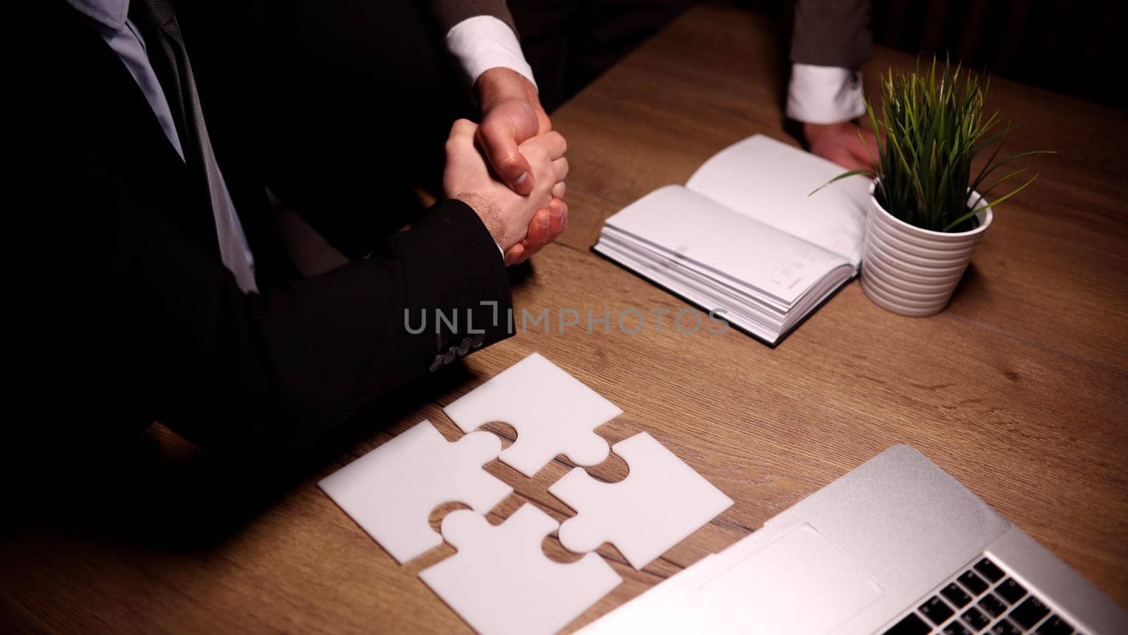 man putting together puzzles on wooden table