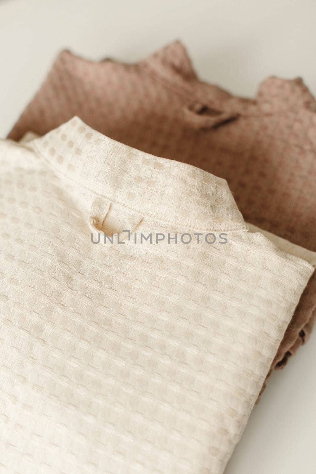 Linen bathrobe is folded, lies on the table. Close-up
