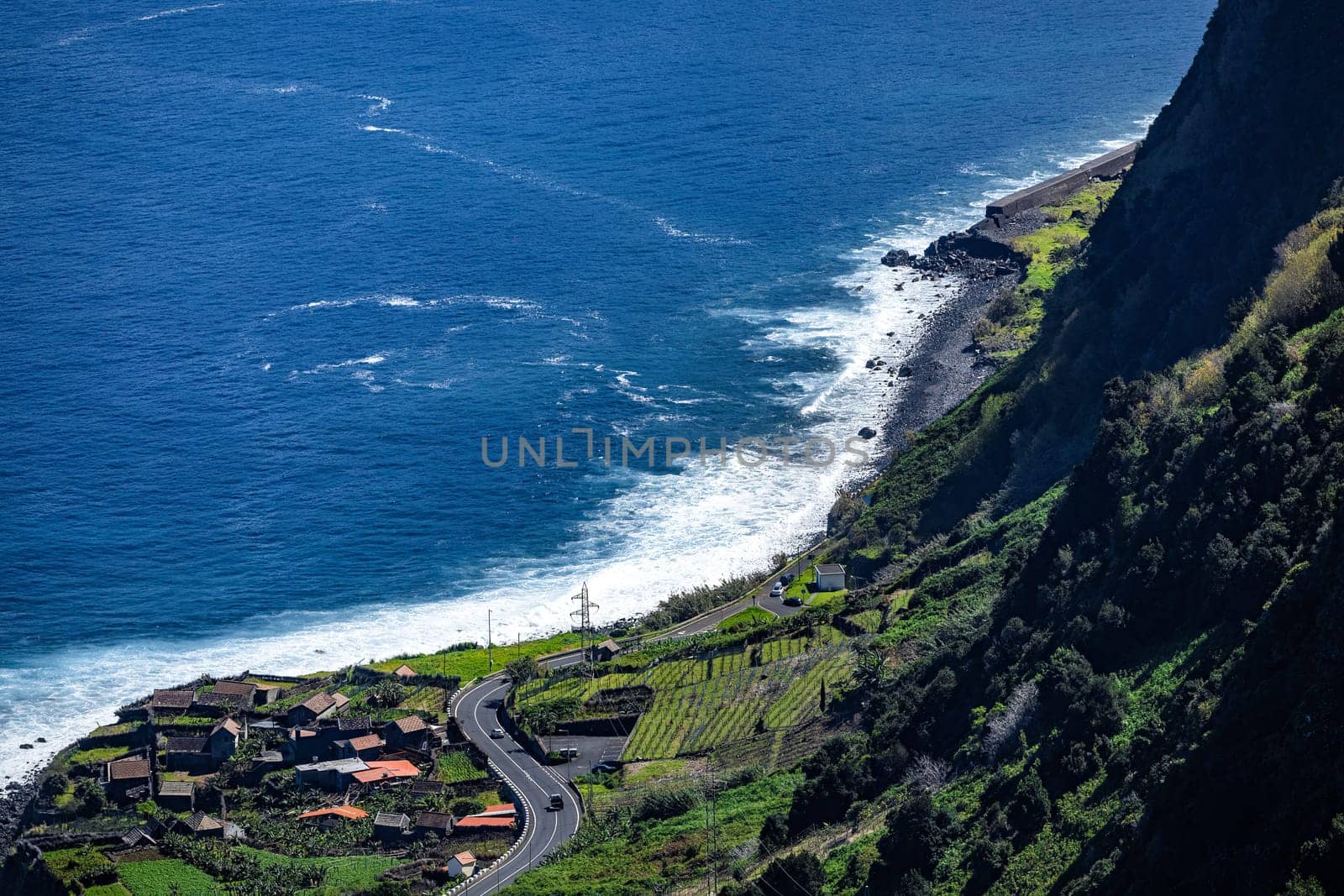 A scenic view of a winding road along a steep cliffside overlooking the ocean