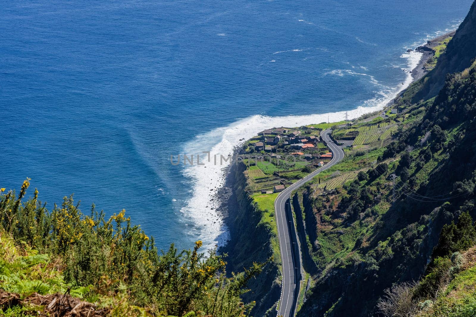 A scenic view of a winding road along a steep cliffside overlooking the ocean