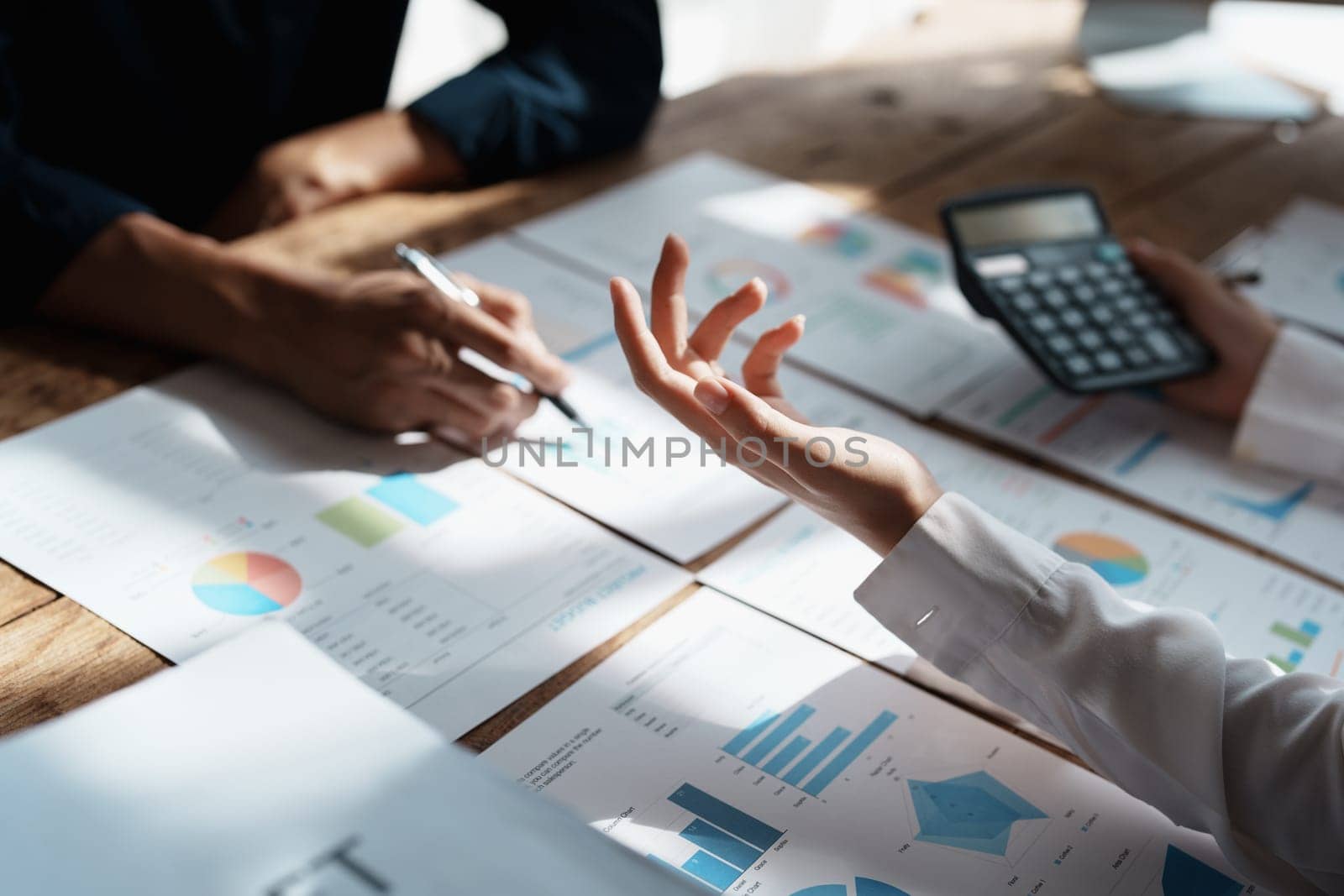 Accountant checking financial statement or counting by calculator income for tax form, Business woman sitting and working with colleague discussing the desk in office. Audit concept by Manastrong