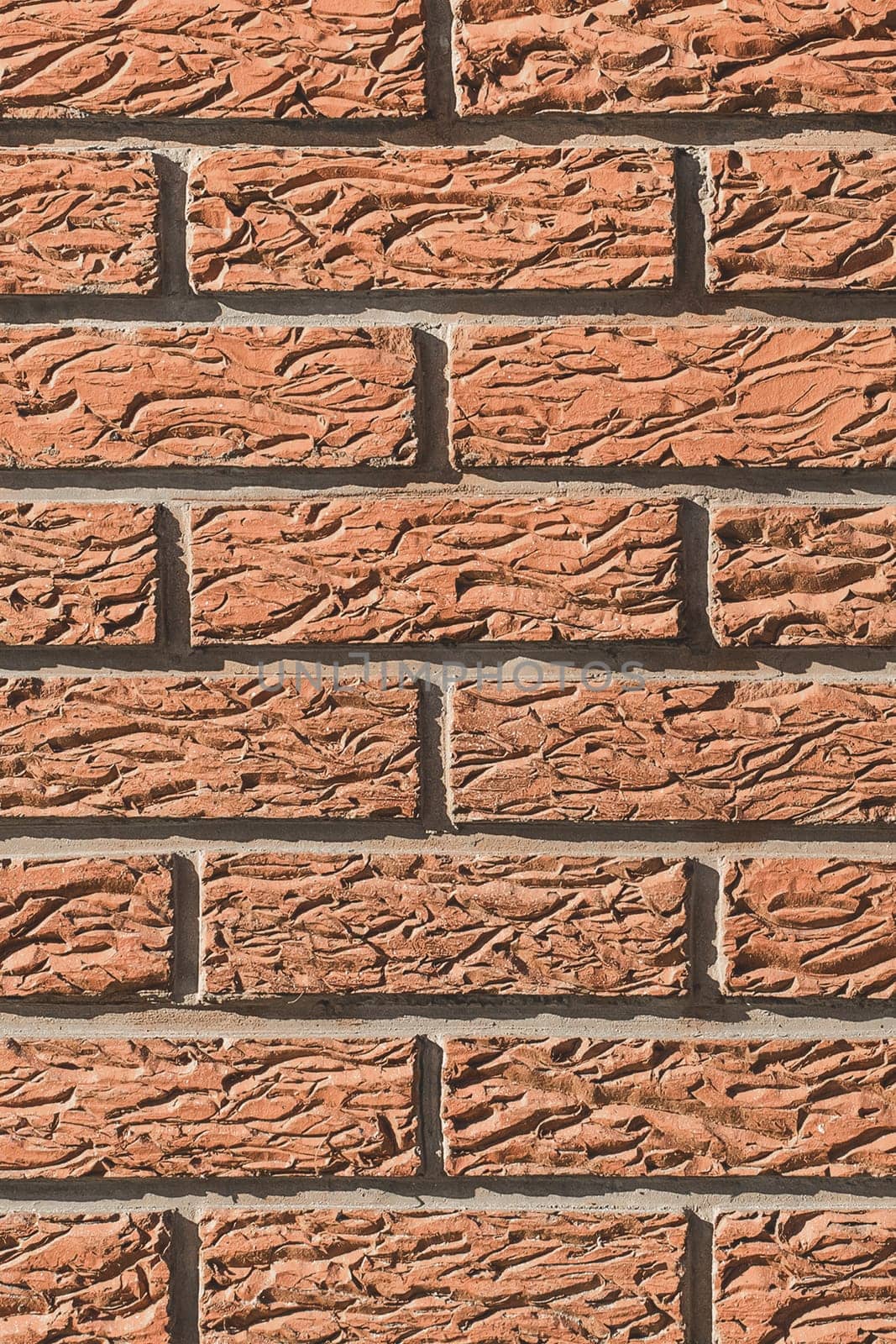 Brown brick wall with abstract decorative stucco plaster pattern modern exterior texture background.