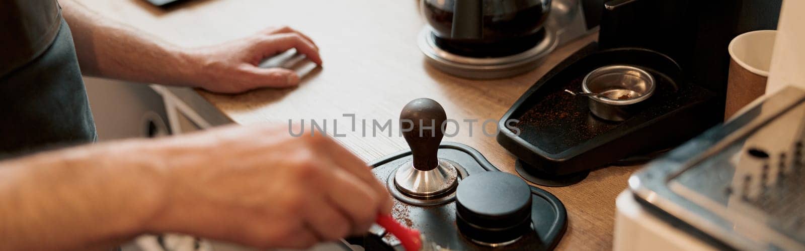 Male coffeeshop owner cleaning up counter for service to customer. Close up