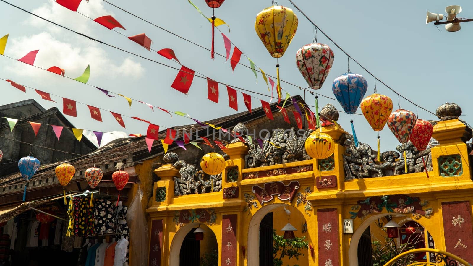Flags and paper lanterns decorate the street near the temple. High quality photo