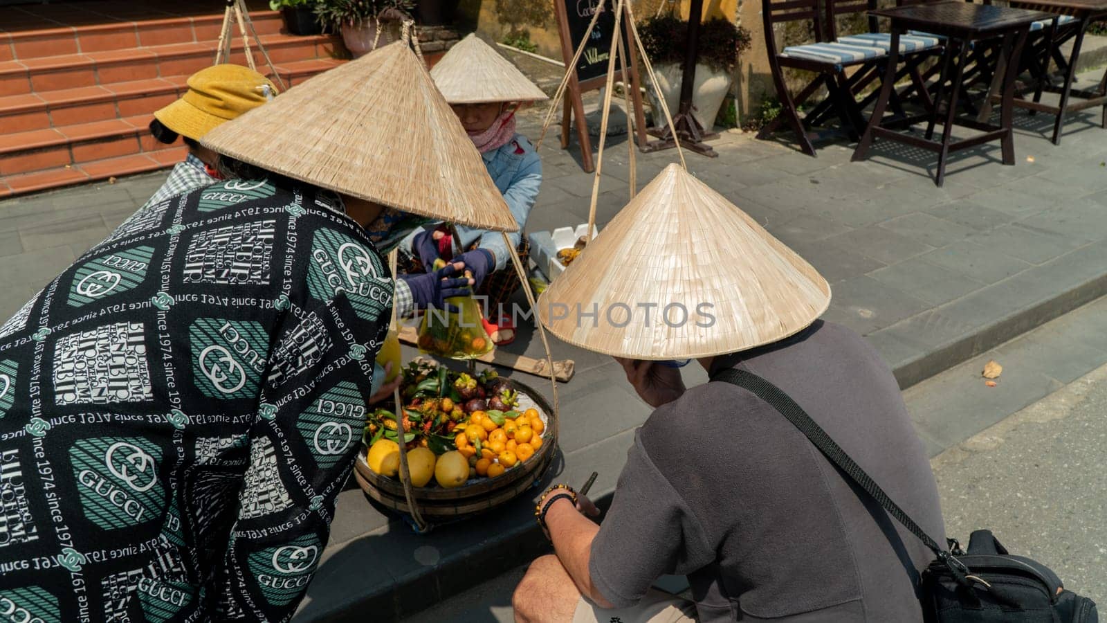 Vietnamese fruit sellers wearing a cone hat by voktybre