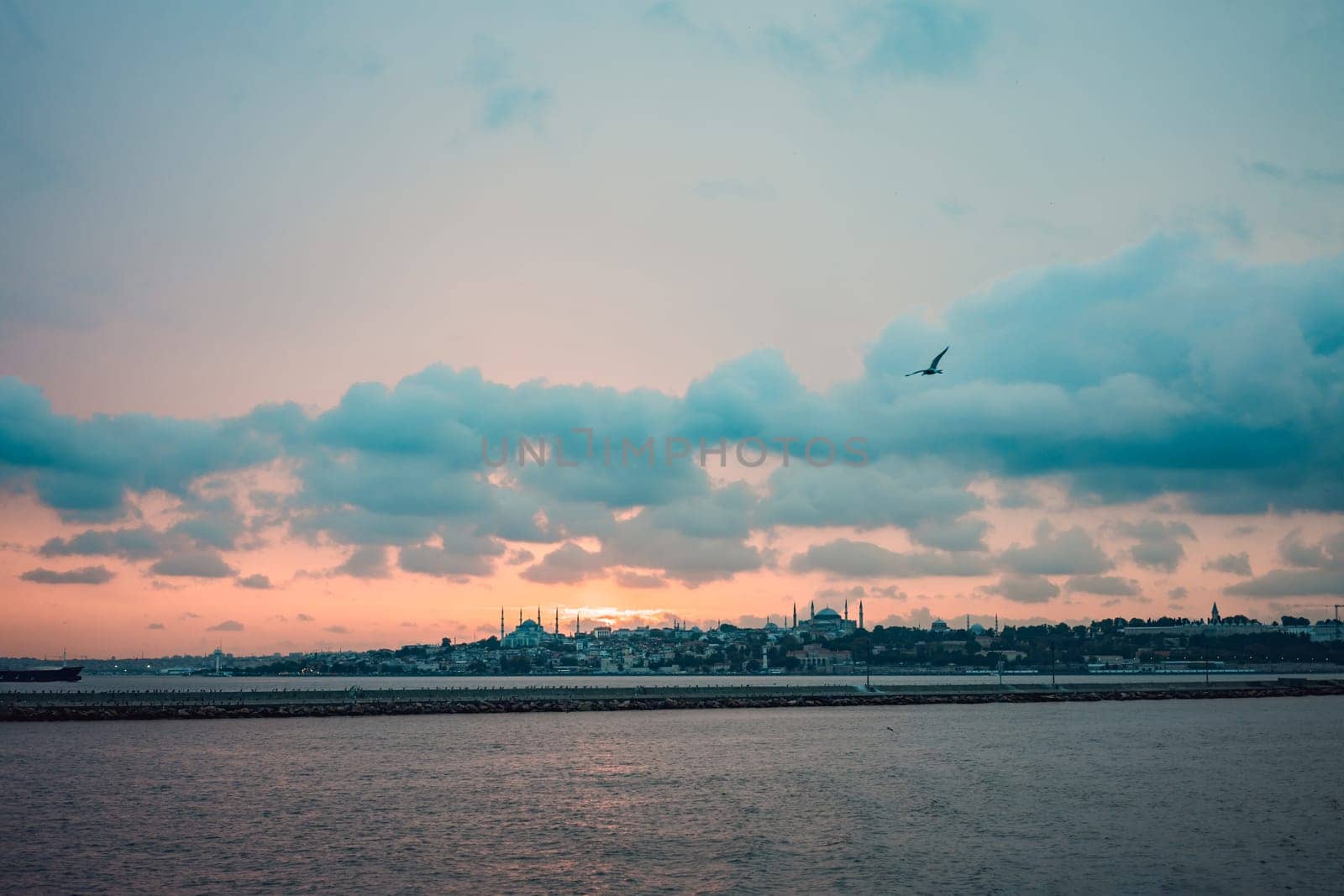 Istanbul at sunset, Turkey. Tourist boat sails on Golden Horn in summer. Beautiful sunny view of Istanbul waterfront with old mosque. Concept of travel, tourism and vacation in Istanbul and Turkey. Turkiye by galitskaya