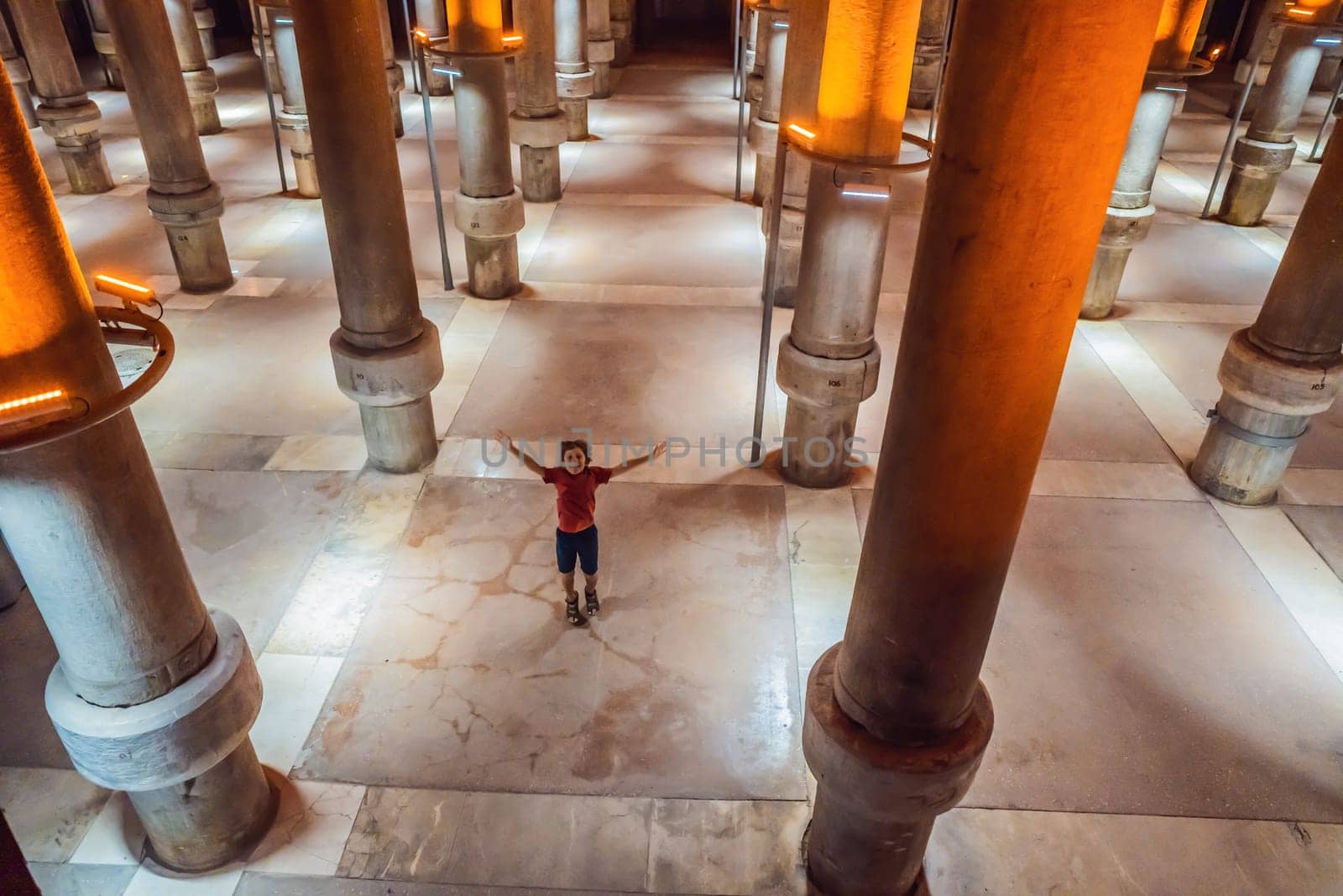 boy tourist enjoying Beautiful cistern in Istanbul. Cistern - underground water reservoir build in 6th century, Istanbul, Turkey, Turkiye.