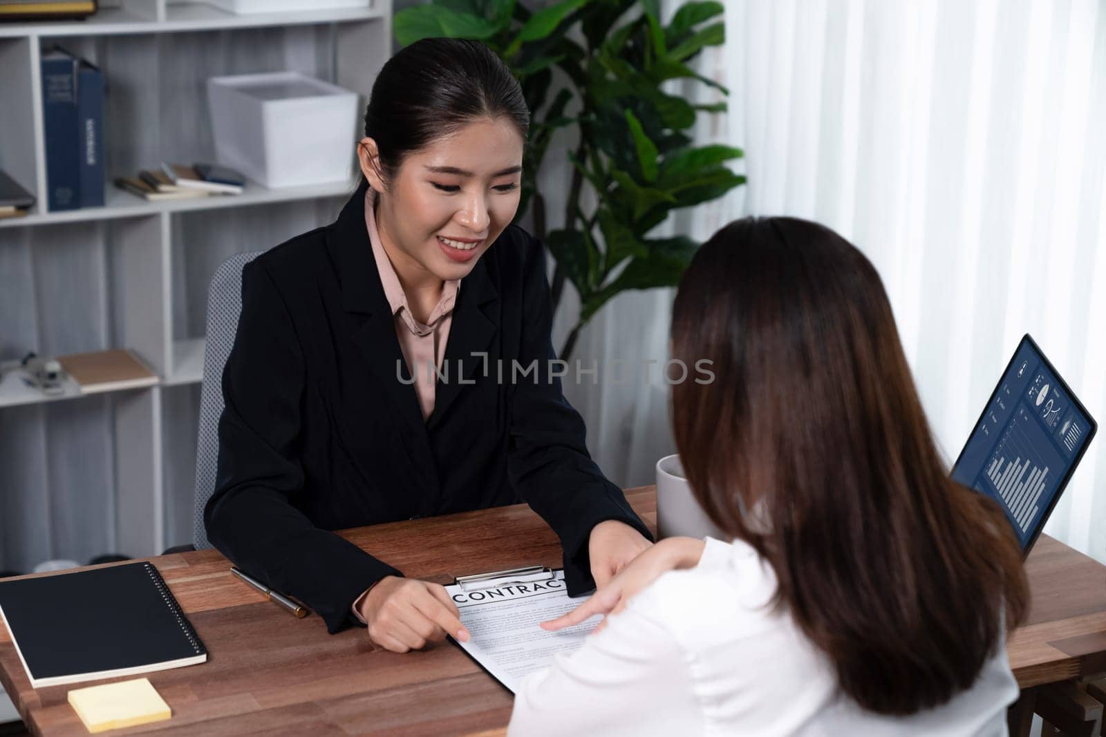 Business deal meeting, young businesswomen carefully reviewing terms and condition of contract agreement papers in office. Corporate lawyer give consultation on contract deal. Enthusiastic