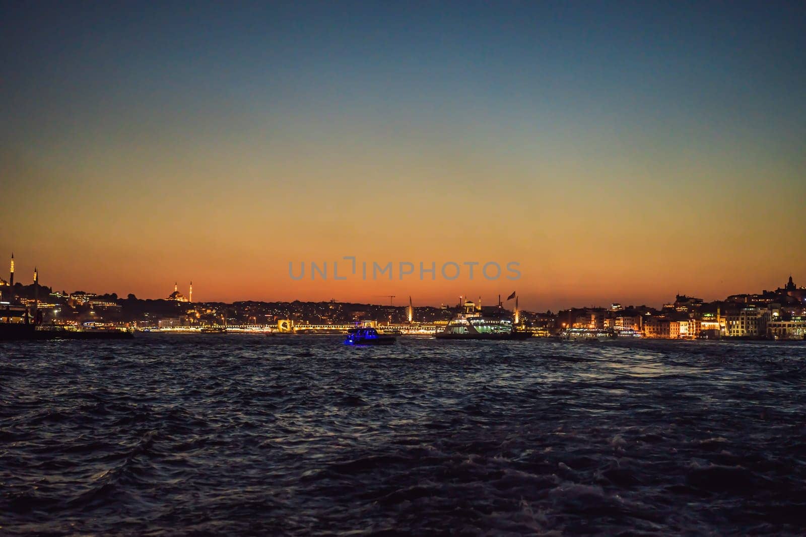 Istanbul at sunset, Turkey. Tourist boat sails on Golden Horn in summer. Beautiful sunny view of Istanbul waterfront with old mosque. Concept of travel, tourism and vacation in Istanbul and Turkey. Turkiye by galitskaya