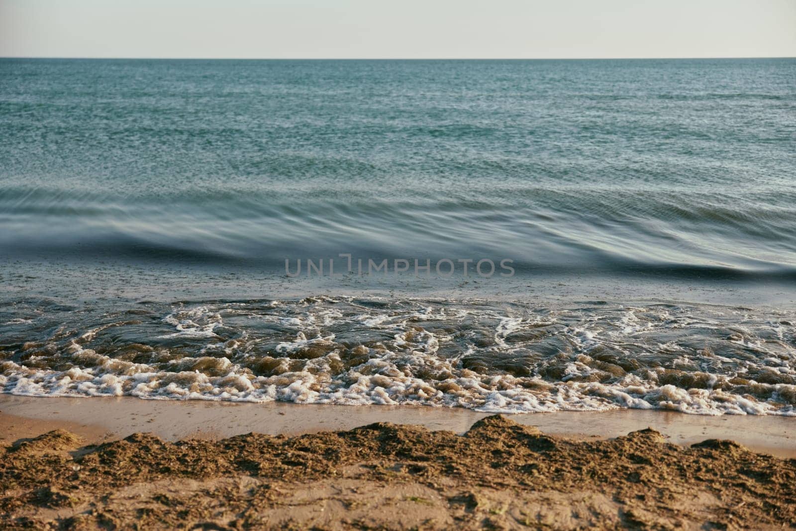 seascape with rolling waves on a calm, sunny day at sunset. High quality photo