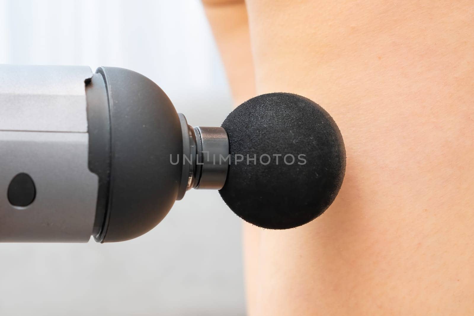 Massage gun for recovery of leg after after gym workout. Physiotherapy concept.