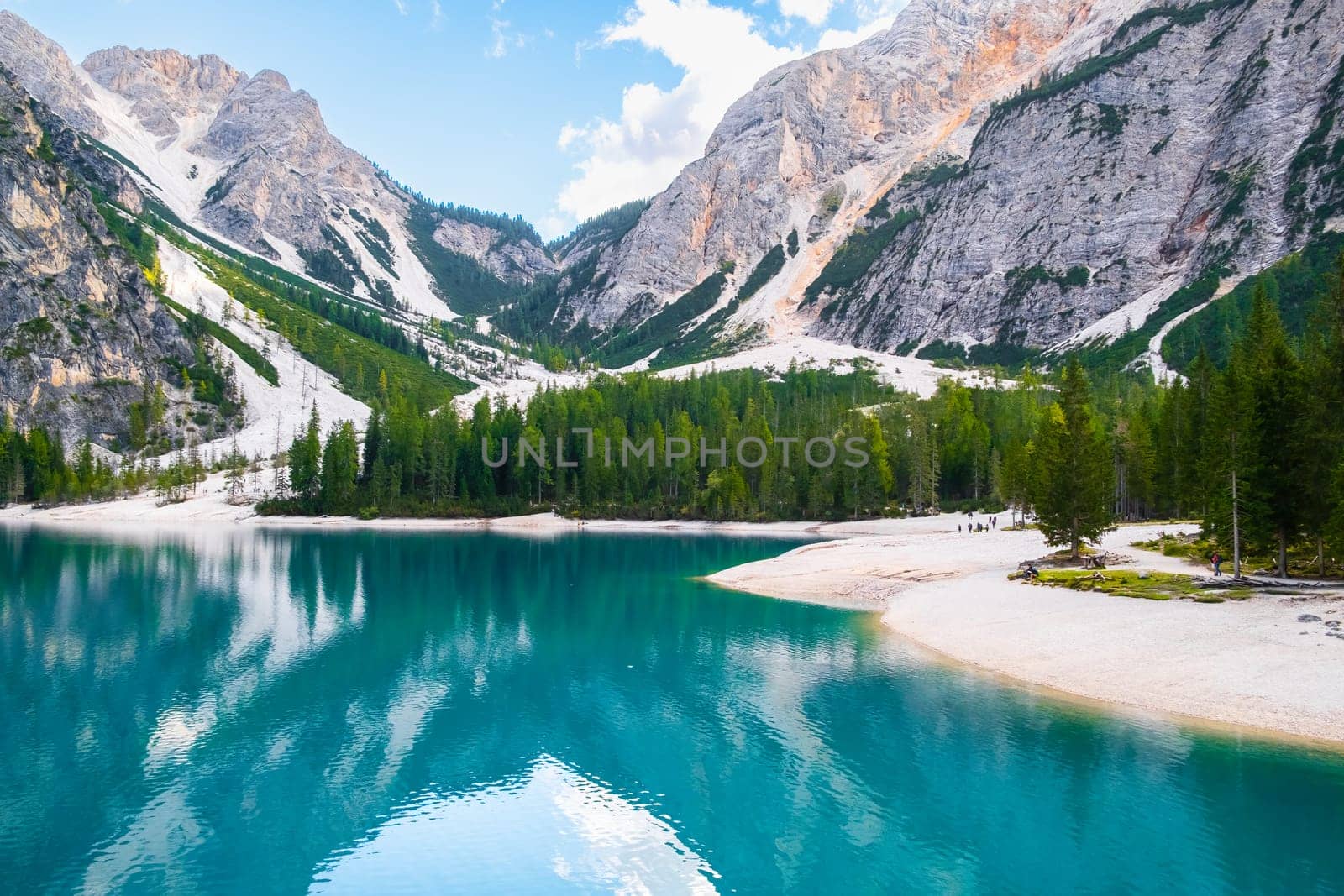Sunny day on Lake Braies with turquoise water and high Dolomites mountains.