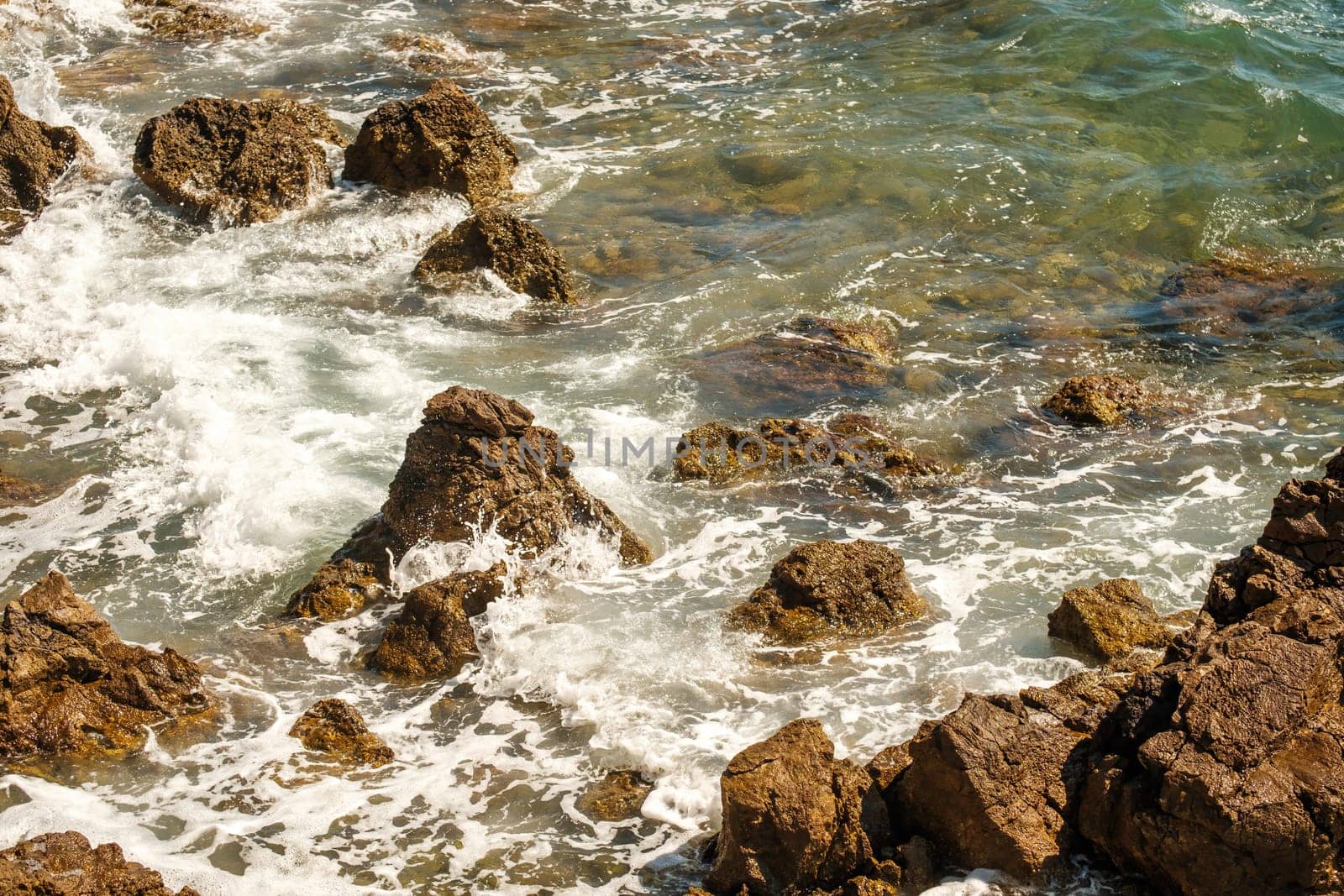 Ocean waves crashing on rocks on coastline at high tide by vladimka