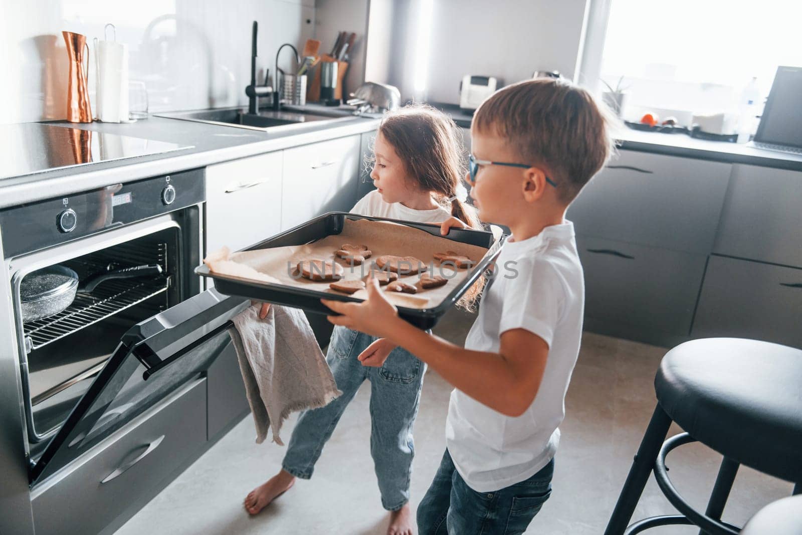 Baking food. Little boy and girl preparing Christmas cookies on the kitchen.