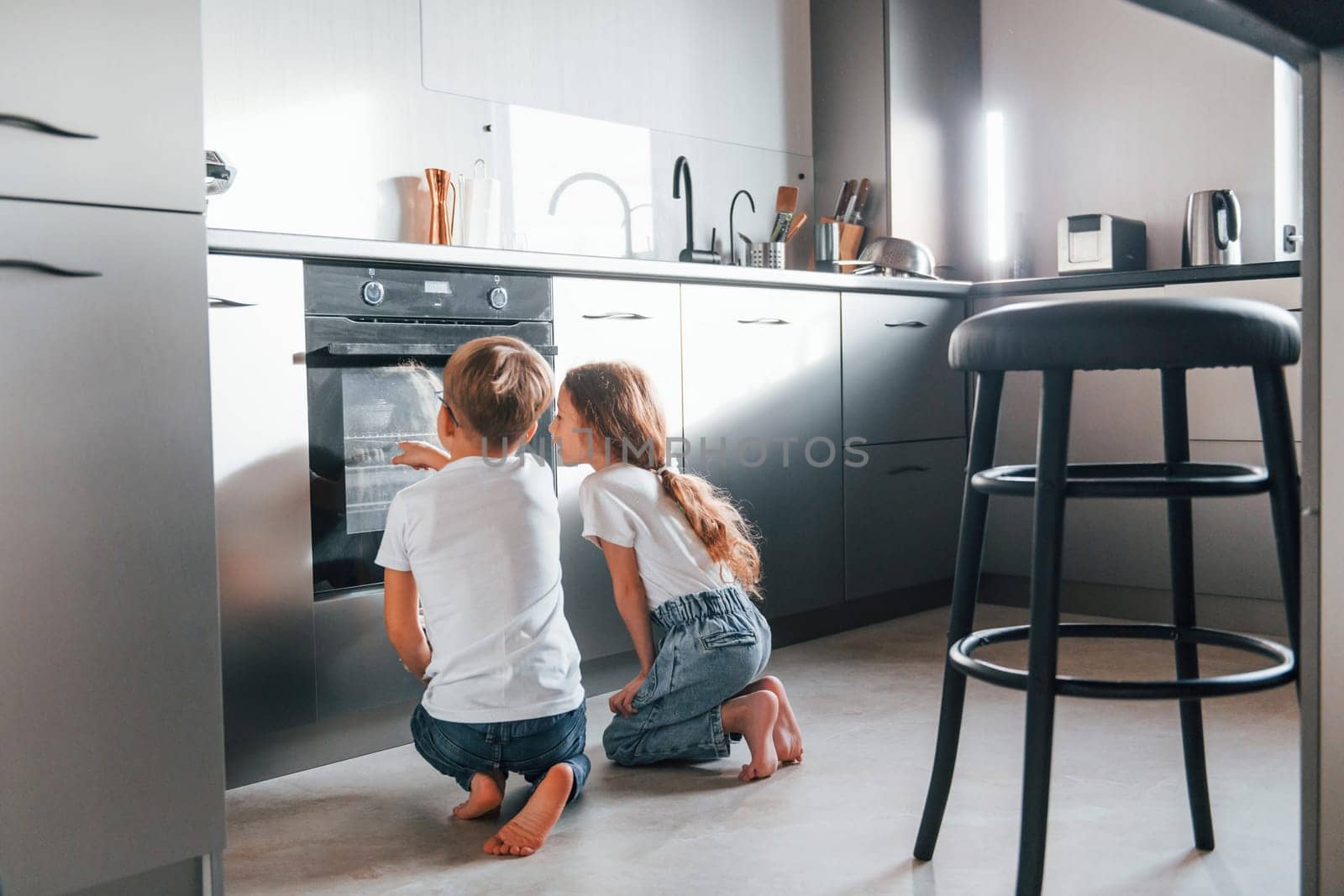 Baking food. Little boy and girl preparing Christmas cookies on the kitchen by Standret