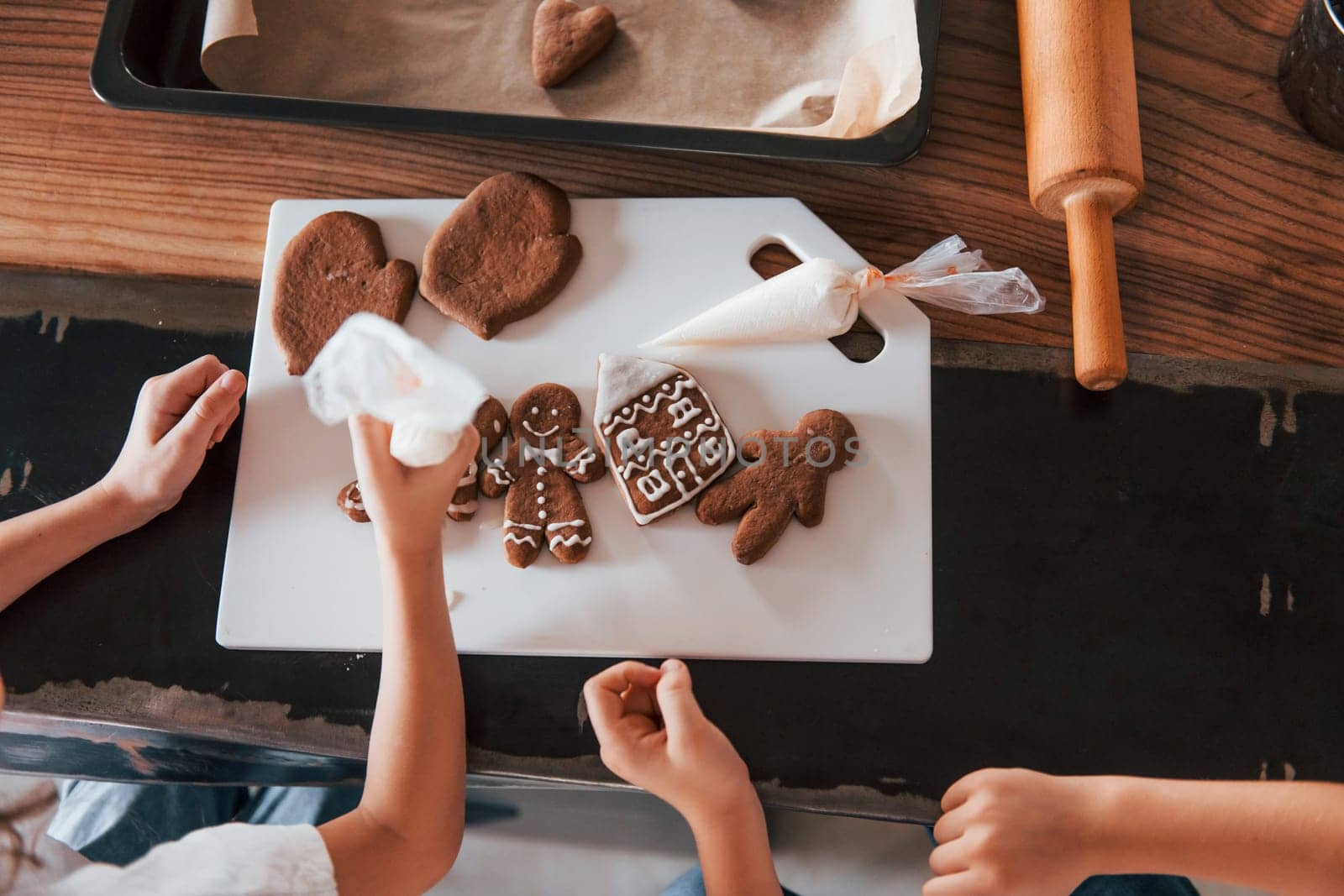 Top view of hands. Little boy and girl preparing Christmas cookies on the kitchen by Standret