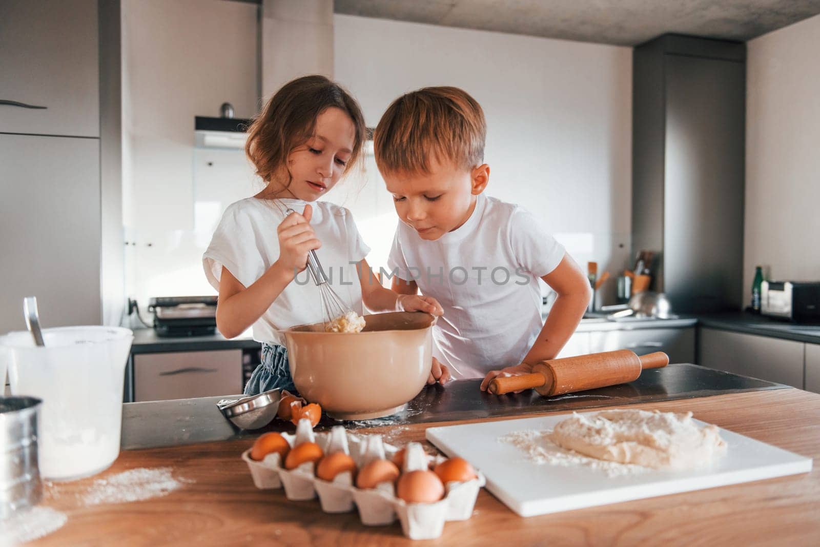 Brother and sister. Little boy and girl preparing Christmas cookies on the kitchen.