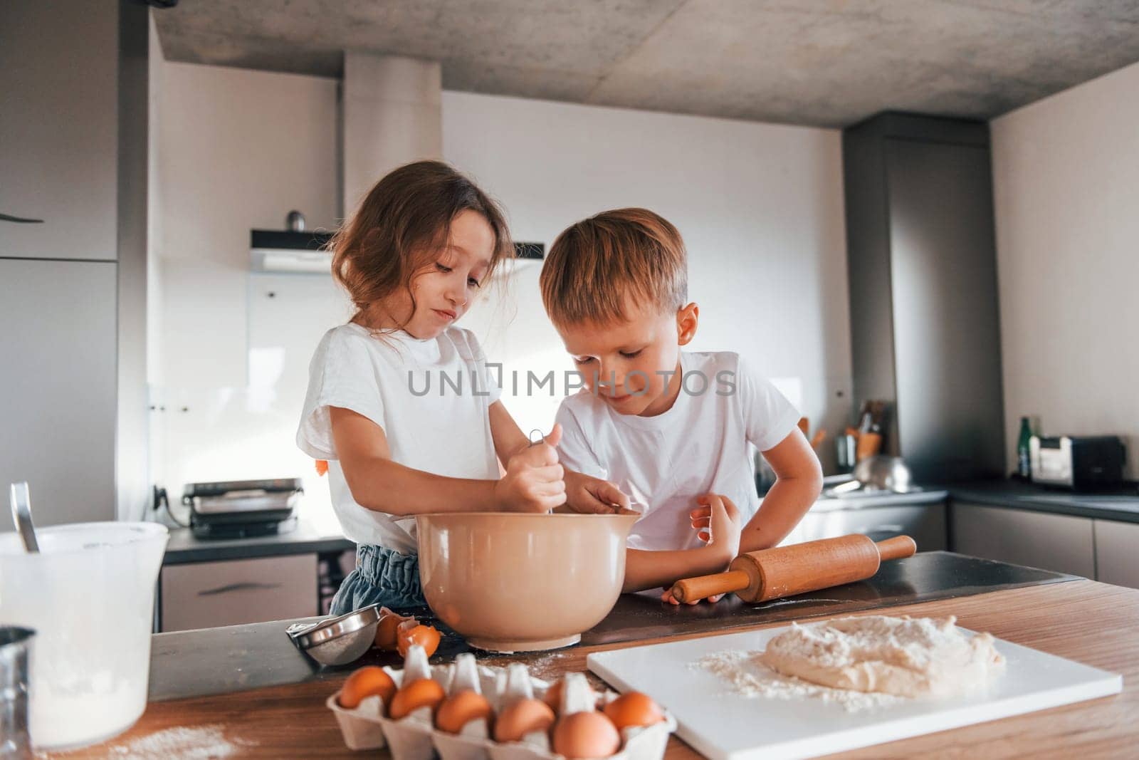 Brother and sister. Little boy and girl preparing Christmas cookies on the kitchen.