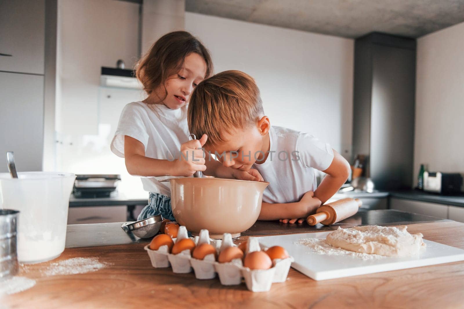 Brother and sister. Little boy and girl preparing Christmas cookies on the kitchen by Standret