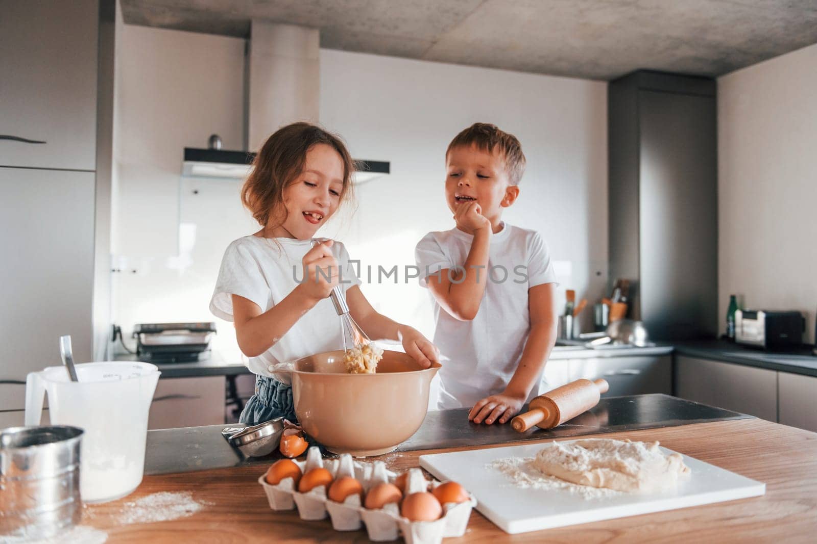 Brother and sister. Little boy and girl preparing Christmas cookies on the kitchen by Standret