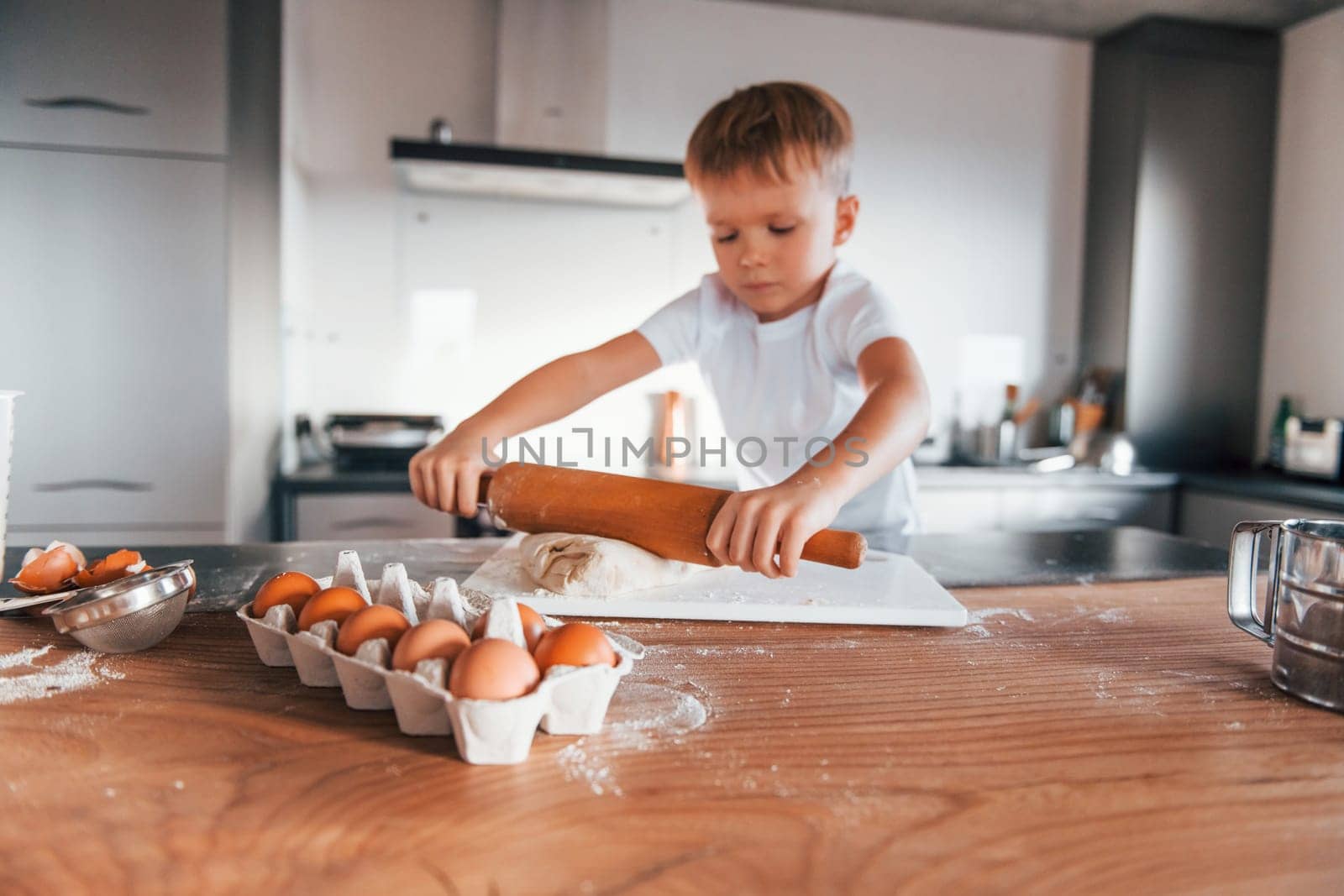 Little boy preparing Christmas cookies on the kitchen.