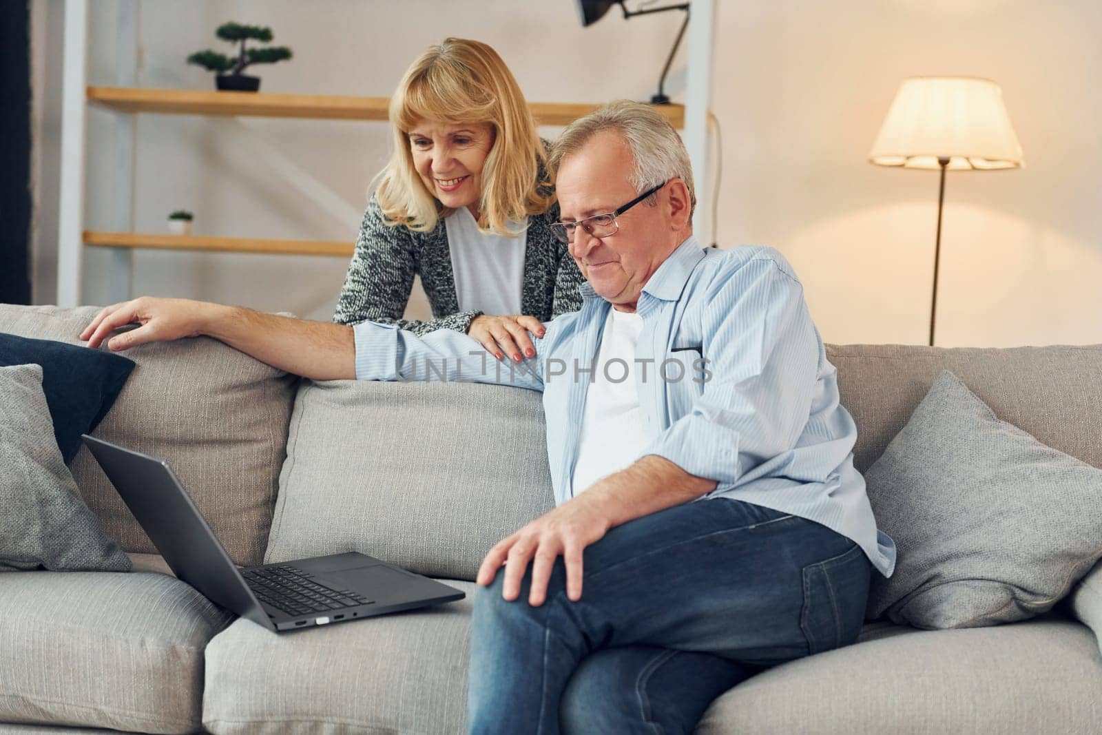 With modern laptop. Senior man and woman is together at home.