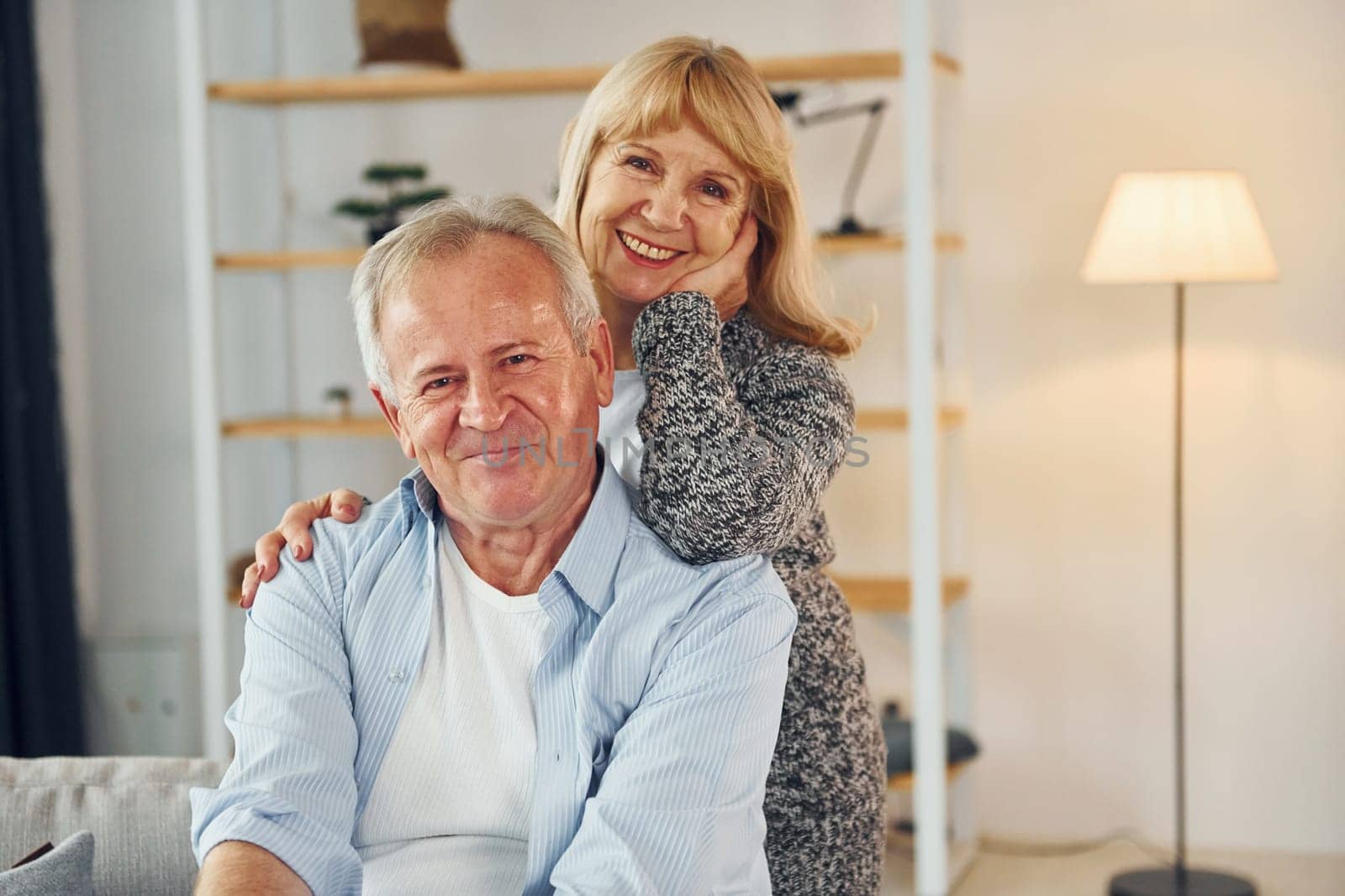 Smiling and embracing. Senior man and woman is together at home.