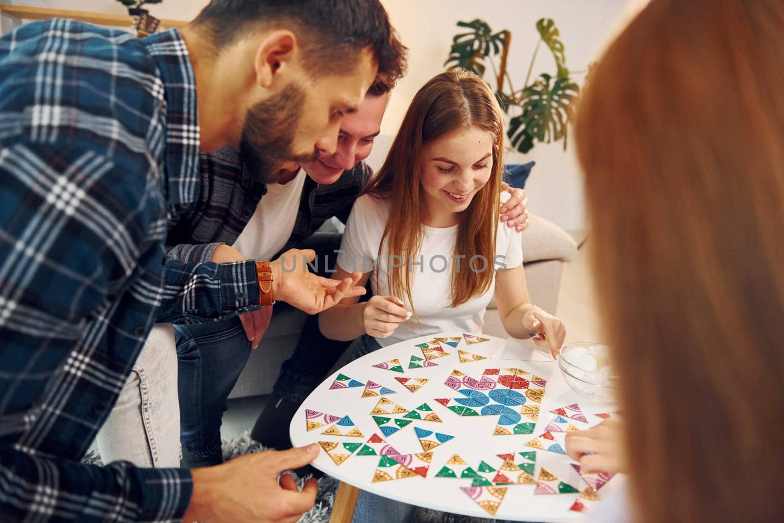 In domestic room. Group of friends have party indoors together.