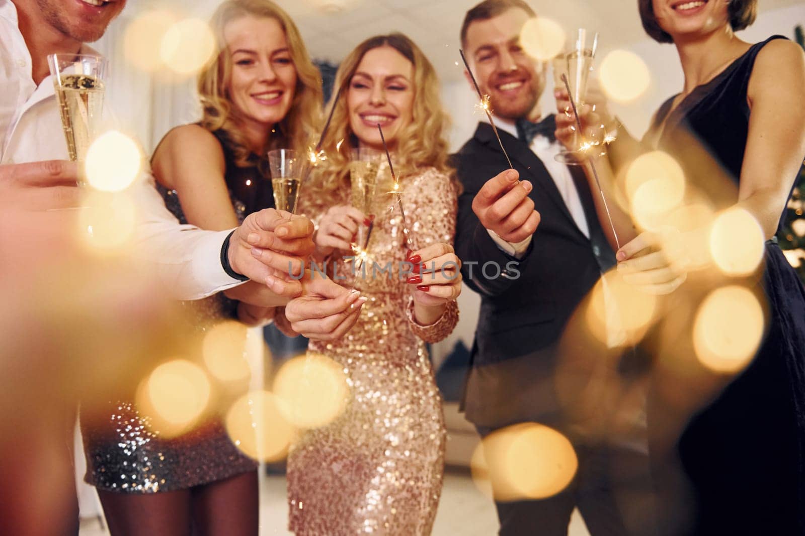 X-mas time. Group of people have a new year party indoors together by Standret