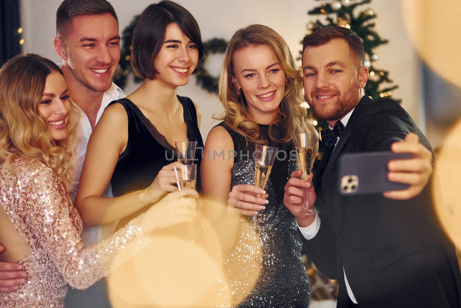 Making selfie. Group of people have a new year party indoors together by Standret