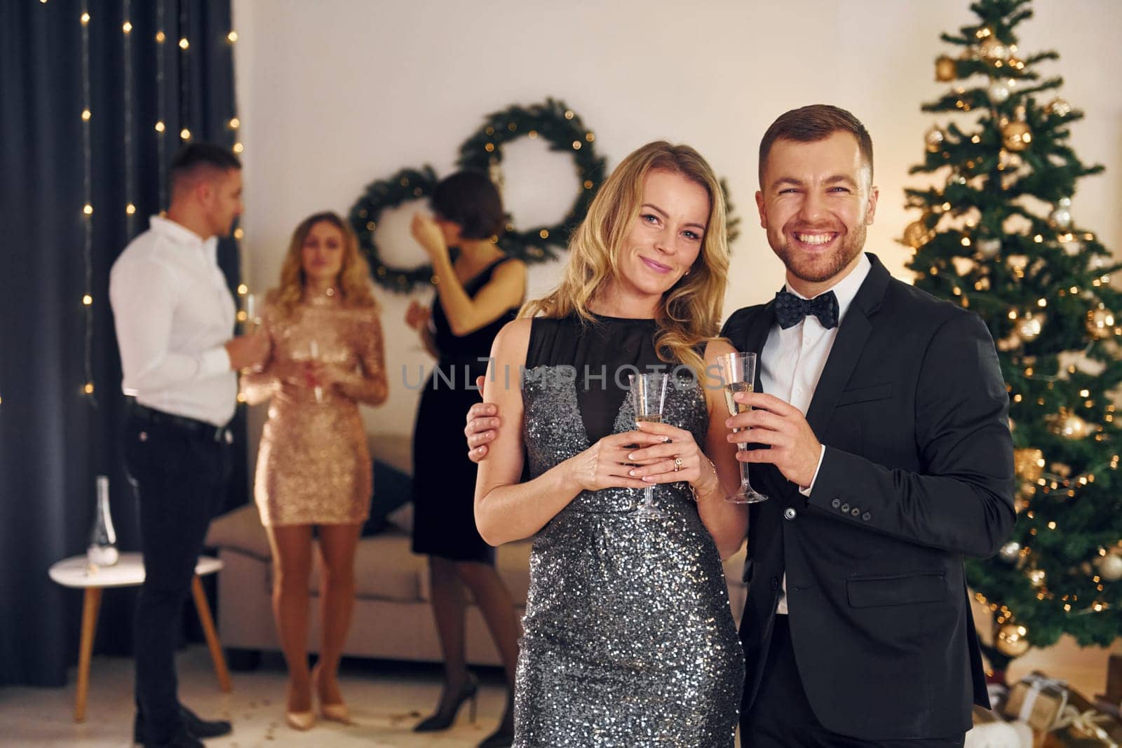 Beautiful couple. Group of people have a new year party indoors together.