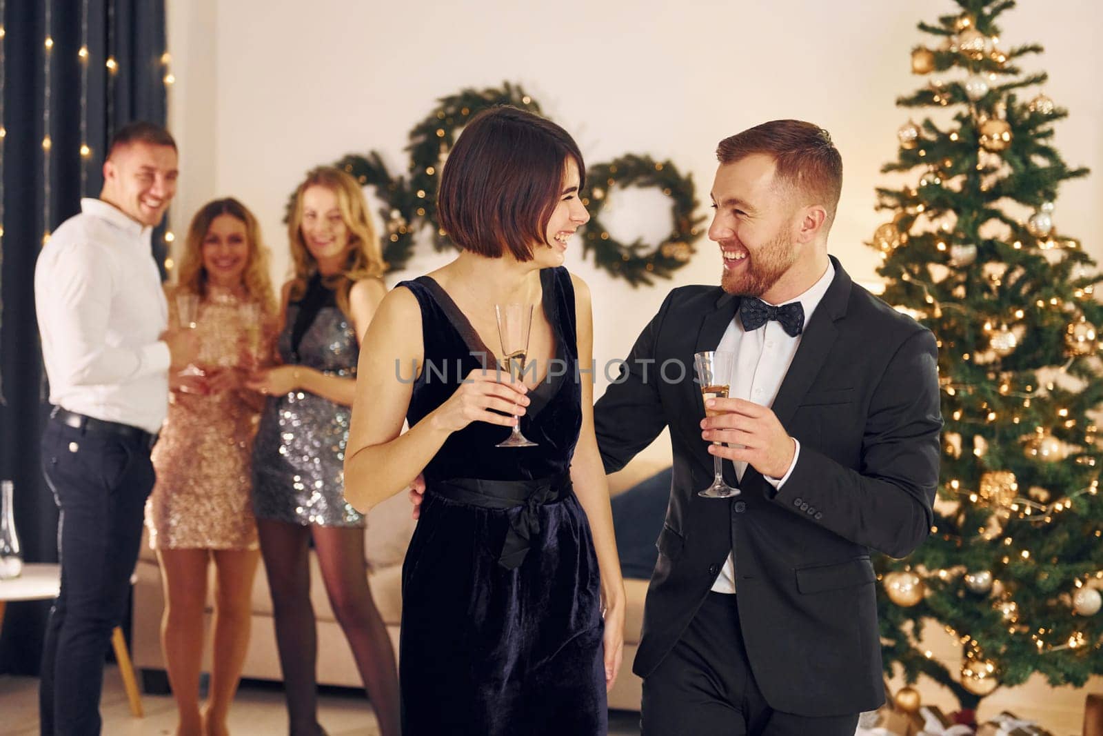 Having conversation. Group of people have a new year party indoors together.