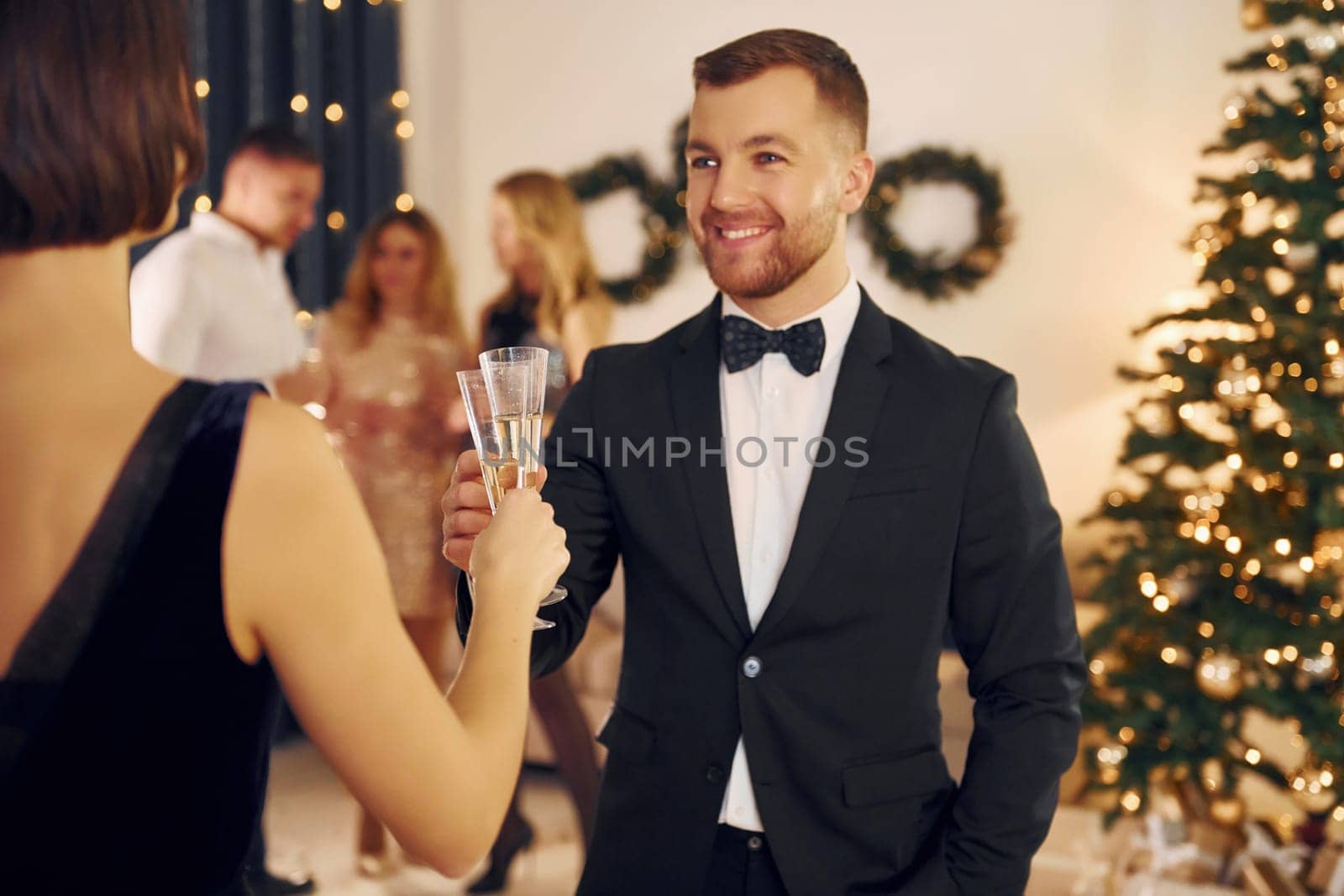 Having conversation. Group of people have a new year party indoors together.